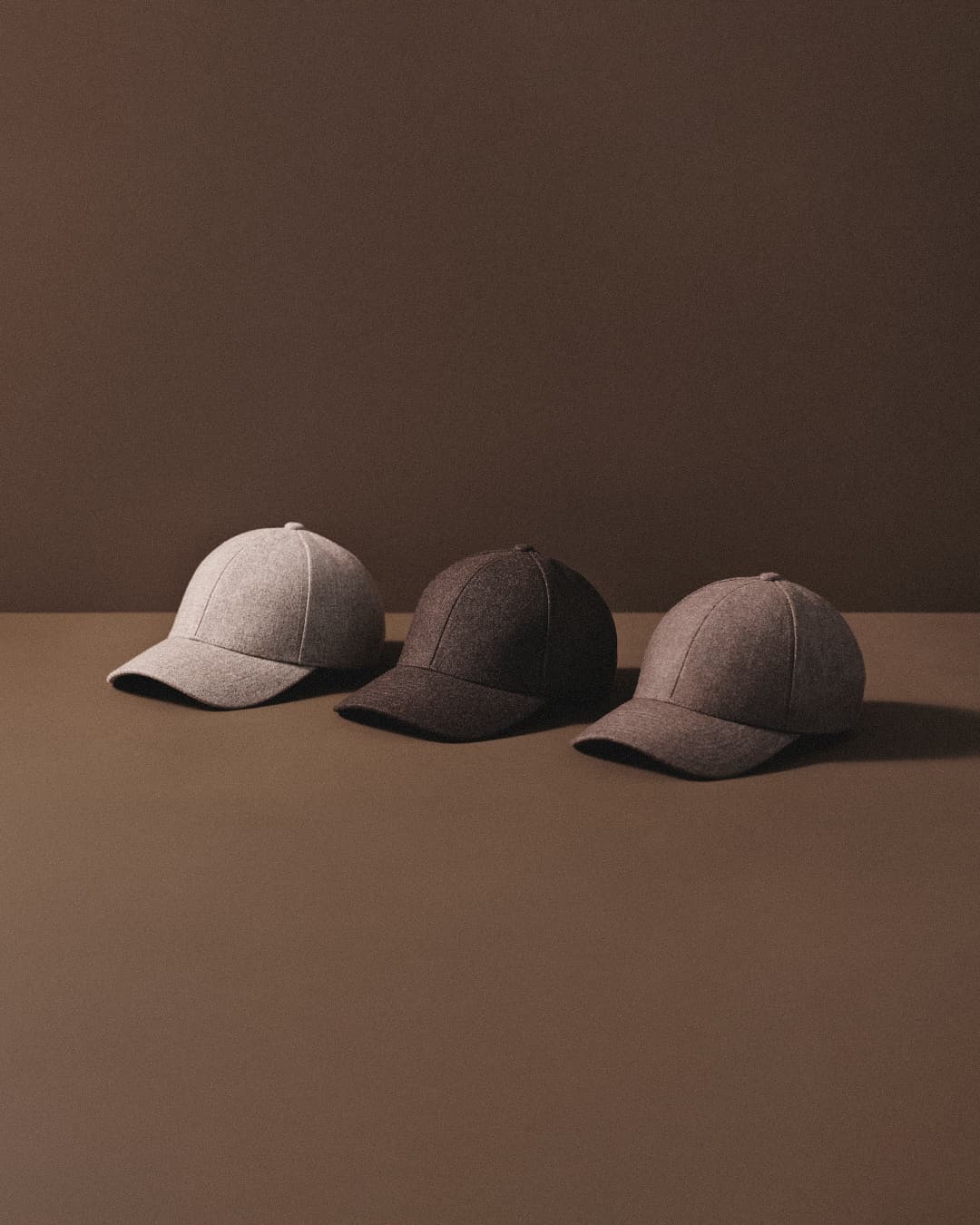 Lineup of wool caps in brown colors with brown background