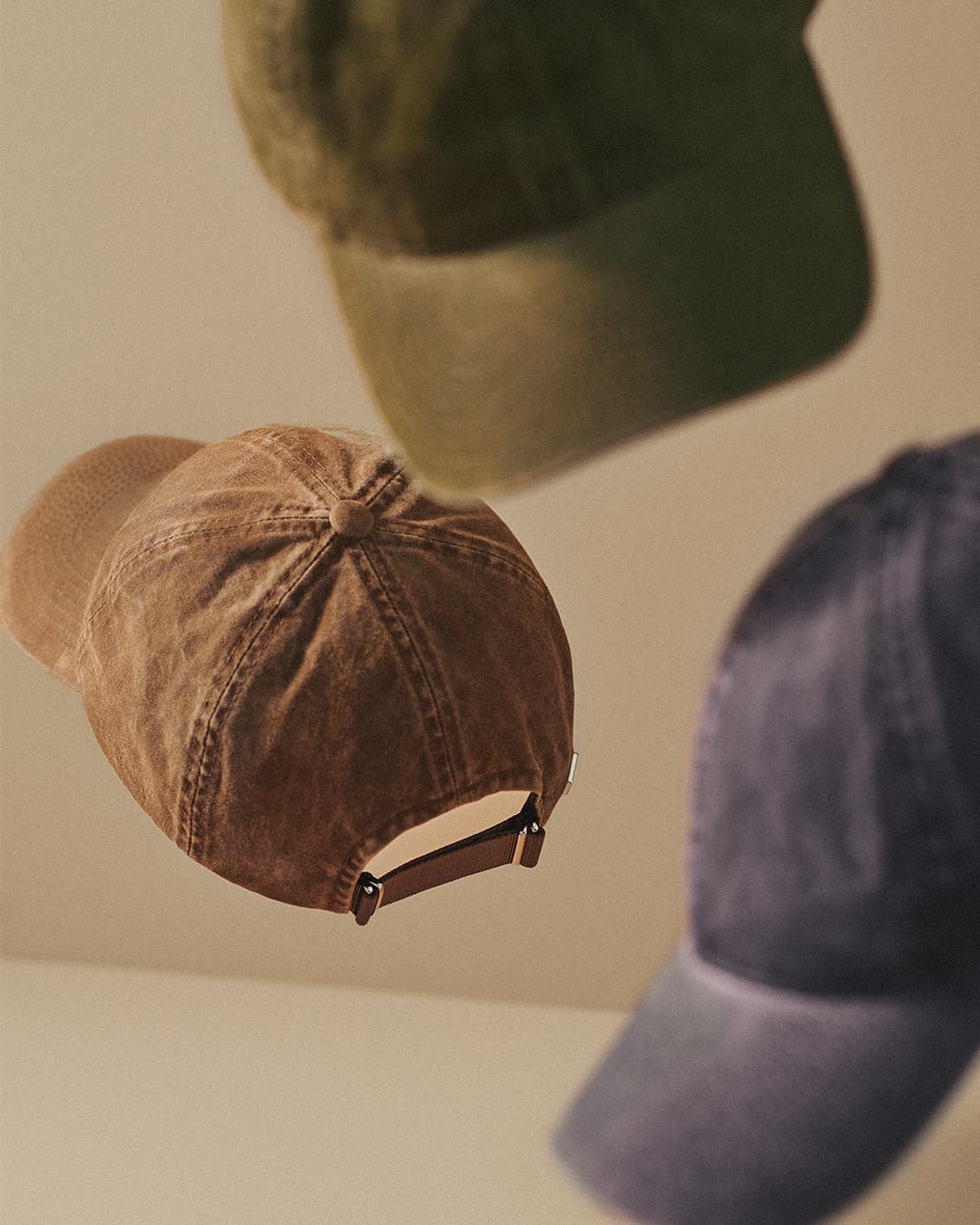 Close view of vintage washed cotton caps in beige, green and navy from varisty headwear