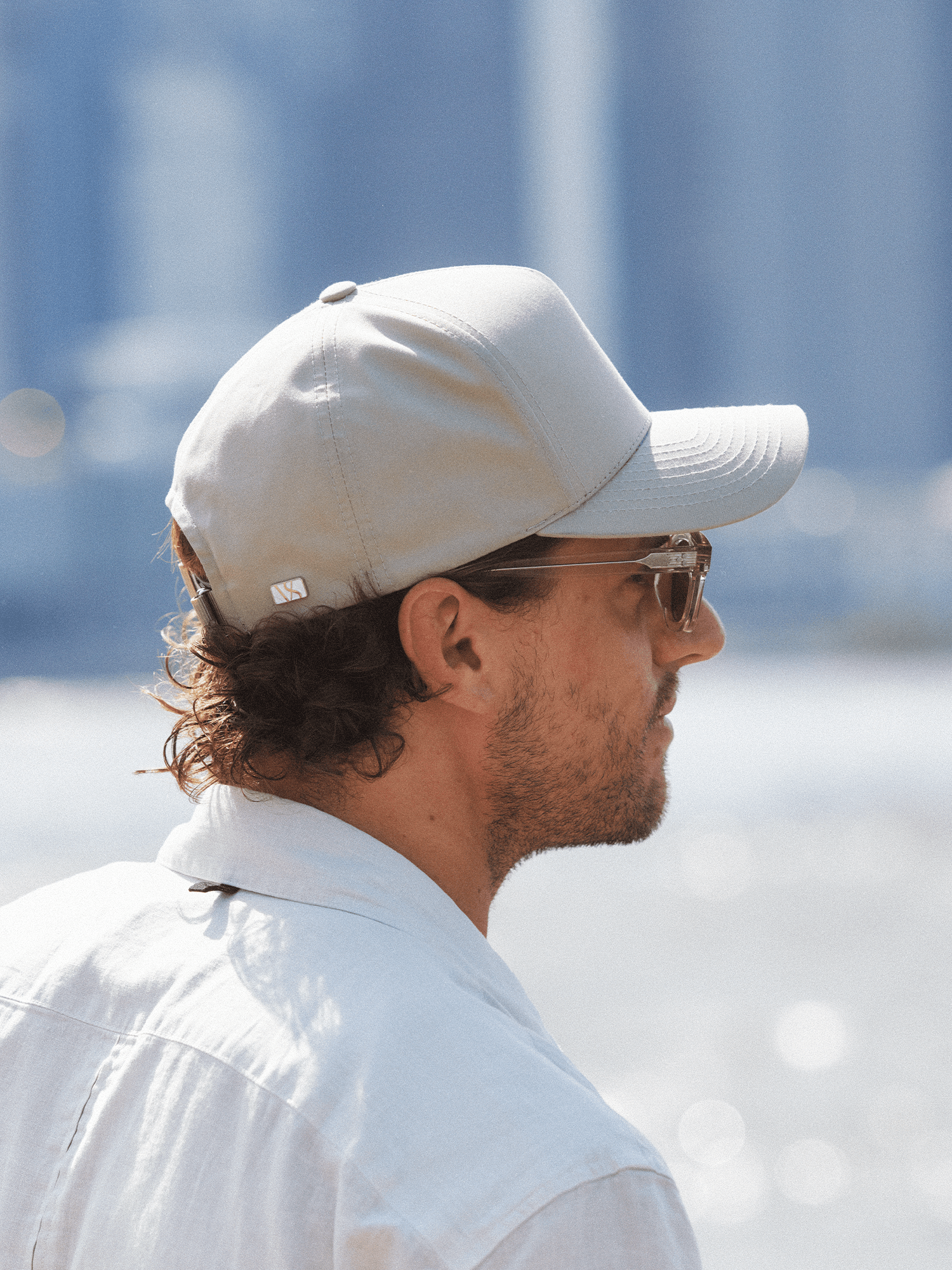 Side view of a male wearing a ventile cotton Cruz cap in beige from varsity headwear