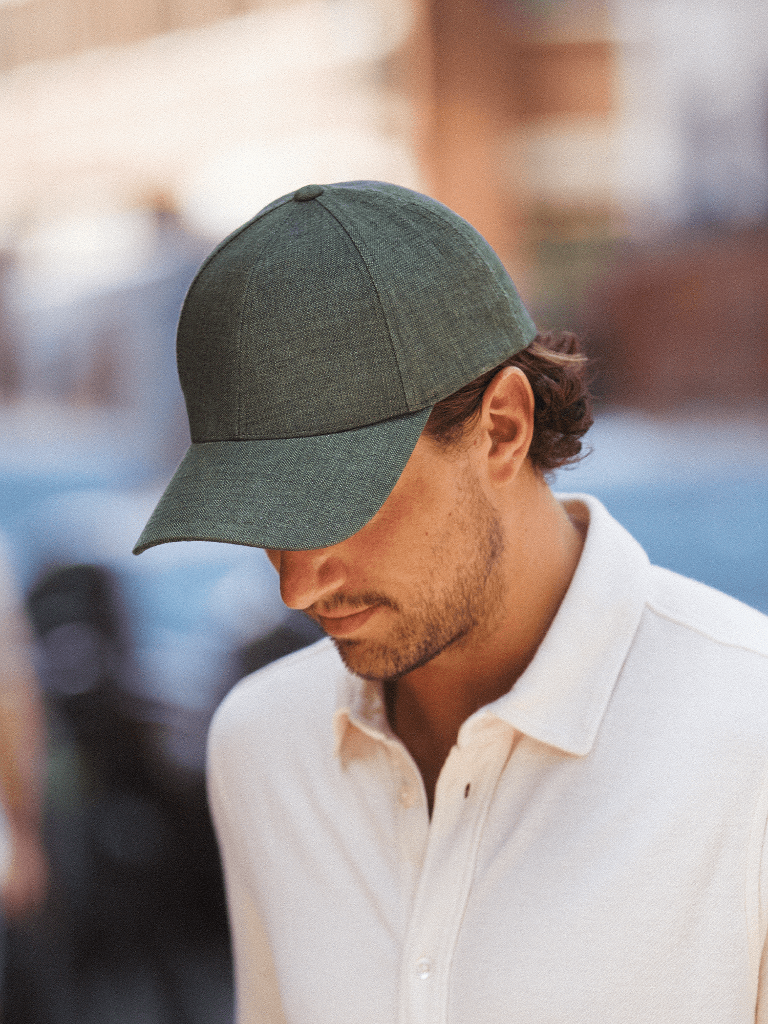 Side view of a male wearing a legacy structured french olive linen cap from varsity headwear