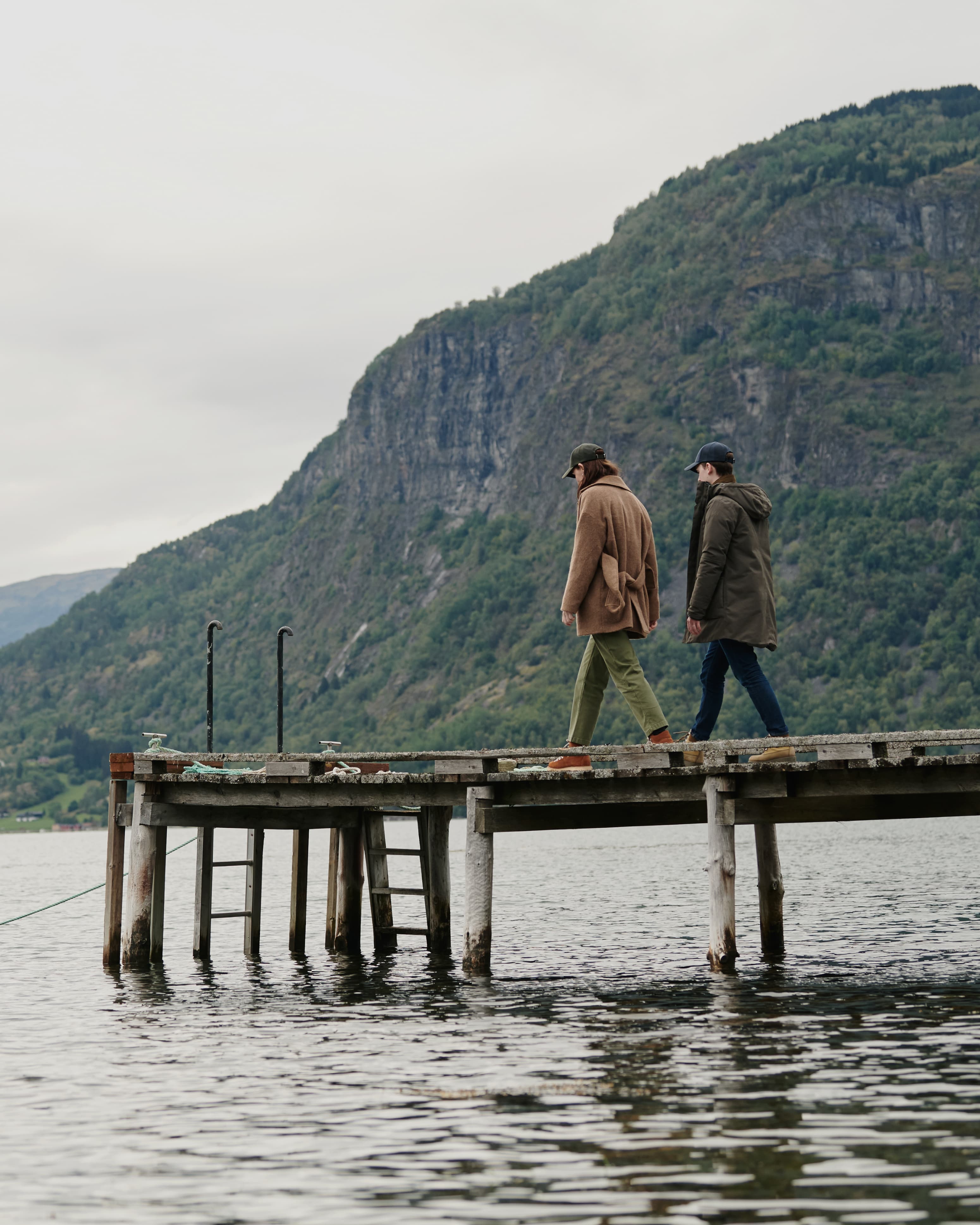 Landscape image of two people wearing varisty headwear caps