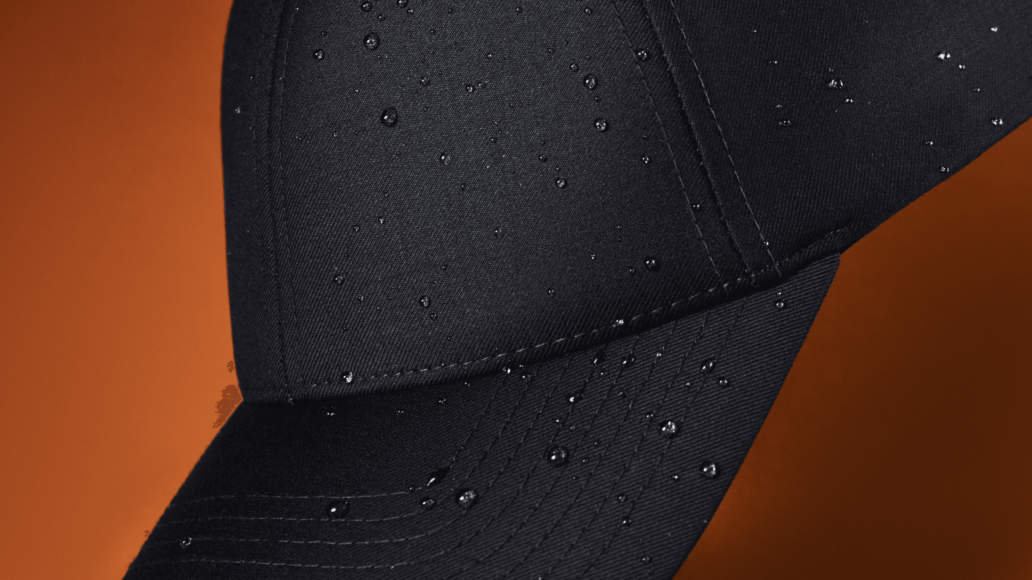 Detailed view showing the fabric features of a varsity headwear cap in rain