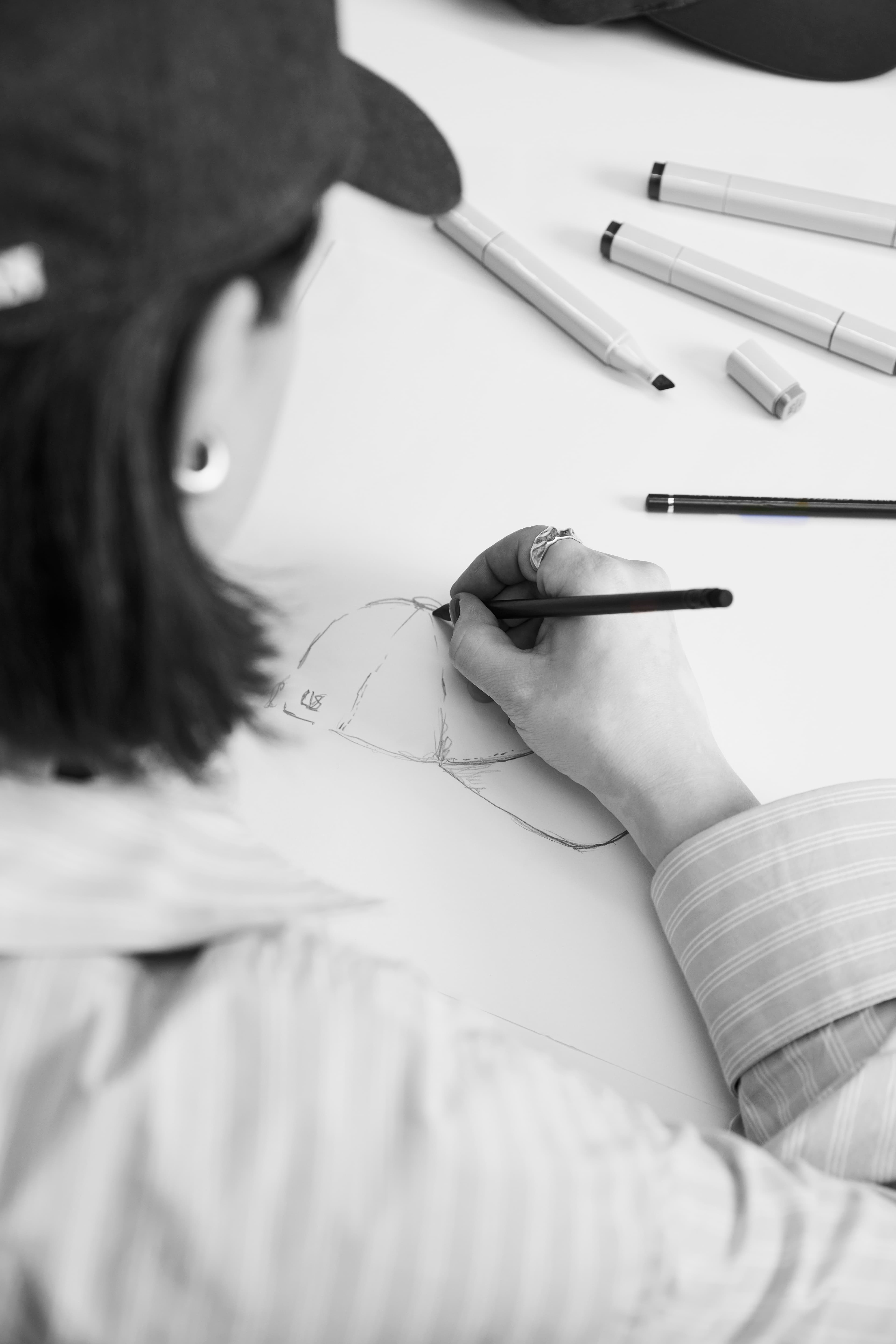 back view of designer drawing cap