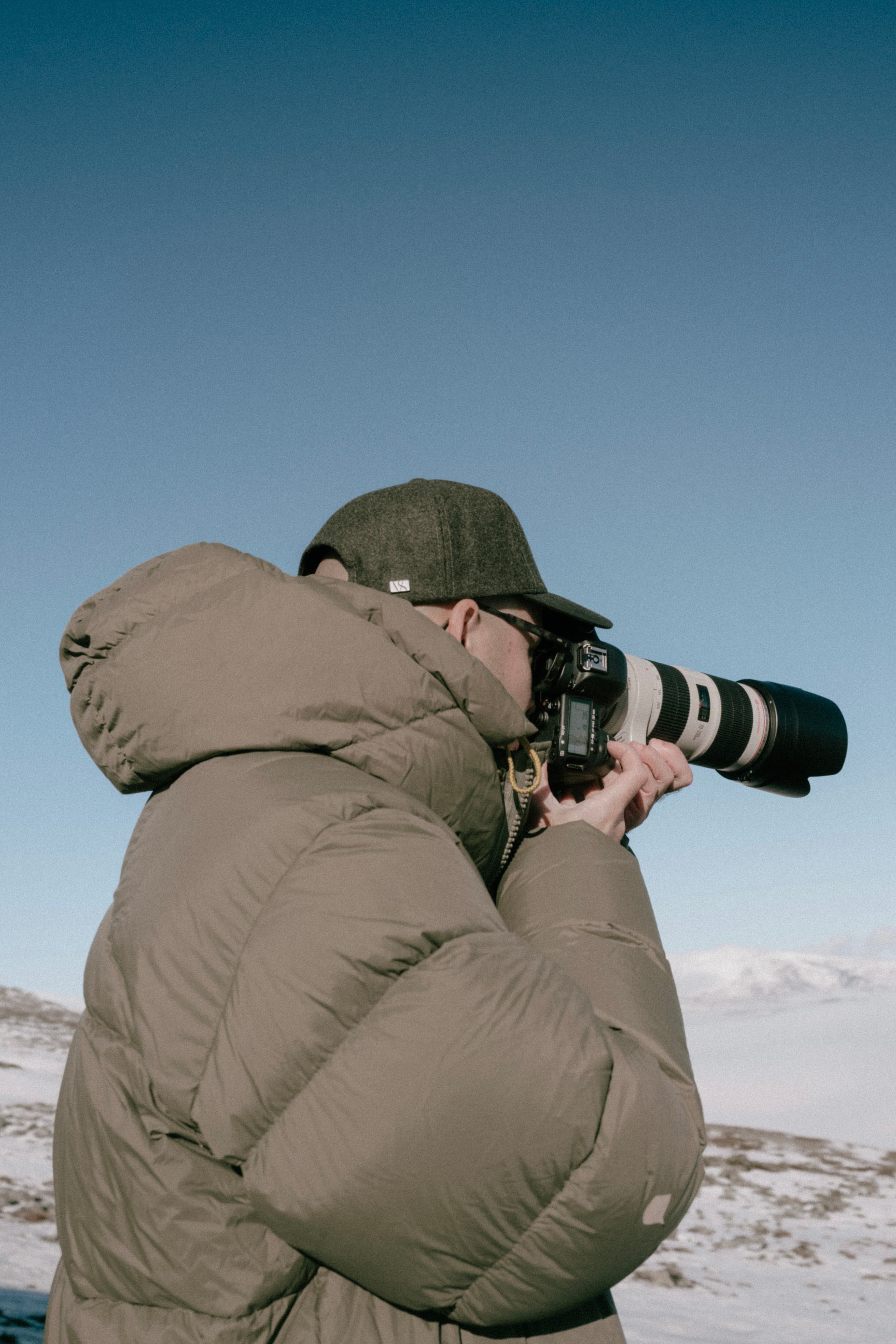 Behind the scenes photo of photographer from the VH holiday 24 shoot wearing a green wool cap