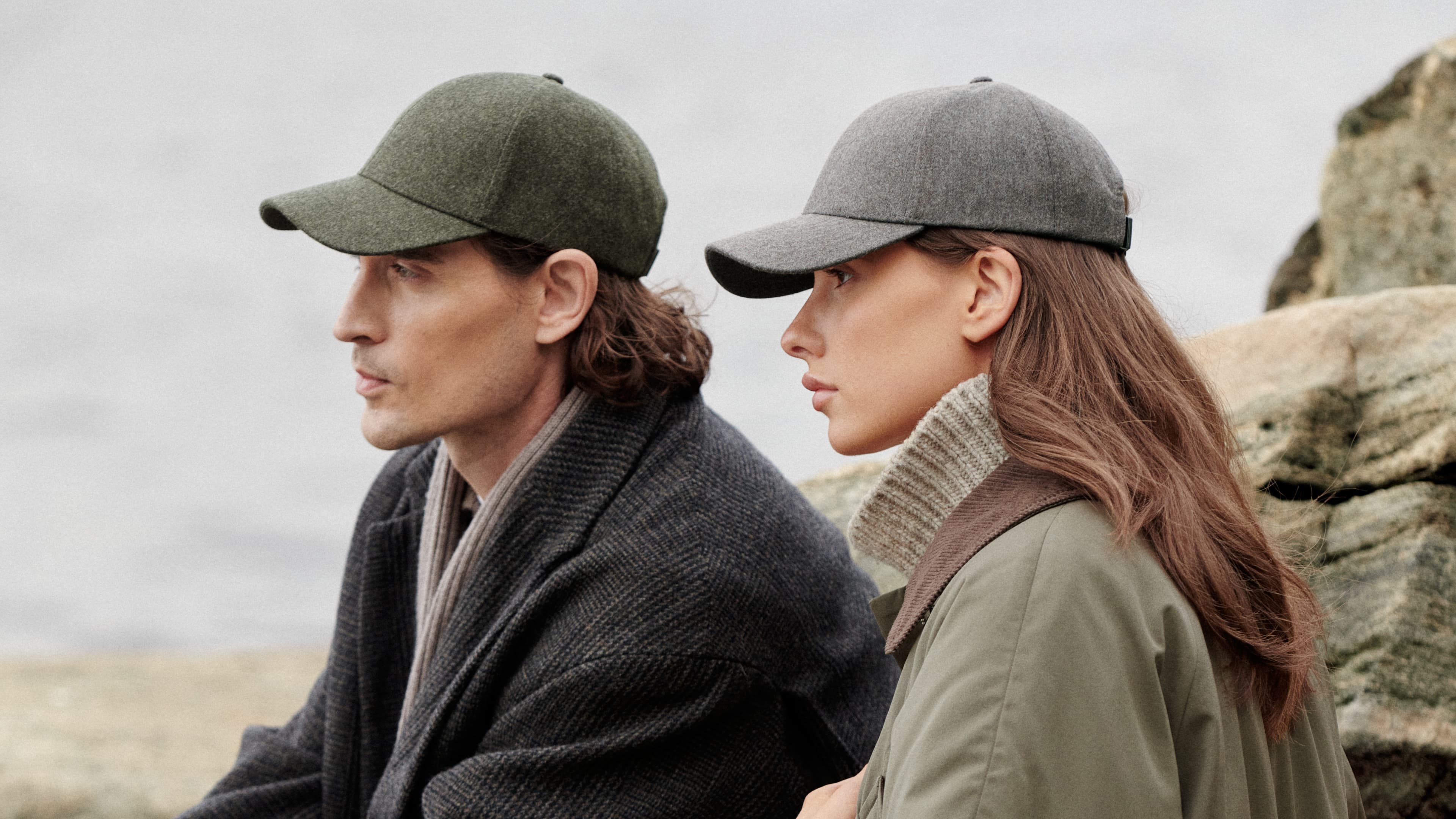 Side view of male model wearing a dark green wool cap and female model wearing a light brown wool cap from varsity headwear