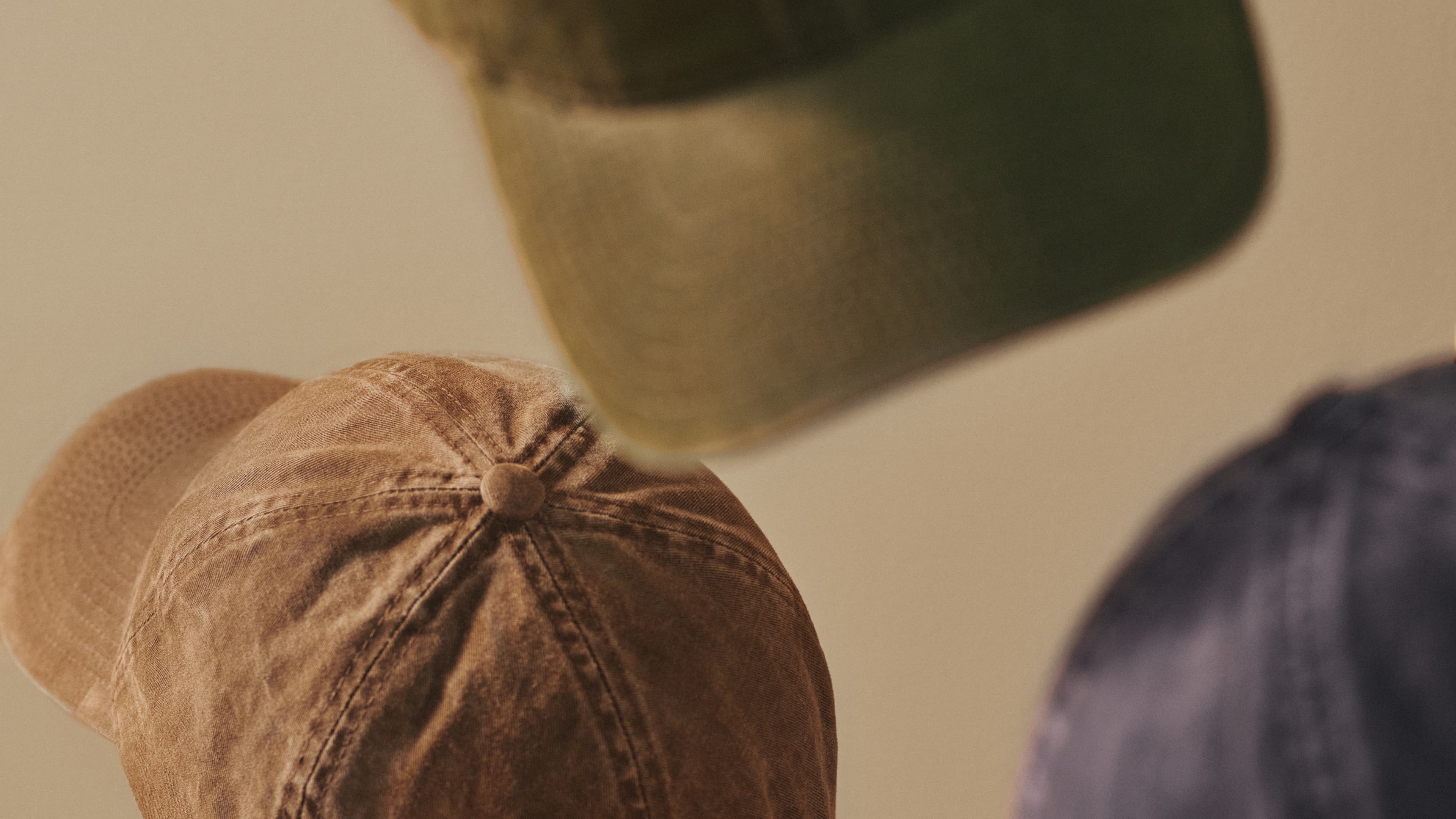 Close view of vintage washed cotton caps in beige, green and navy from varisty headwear