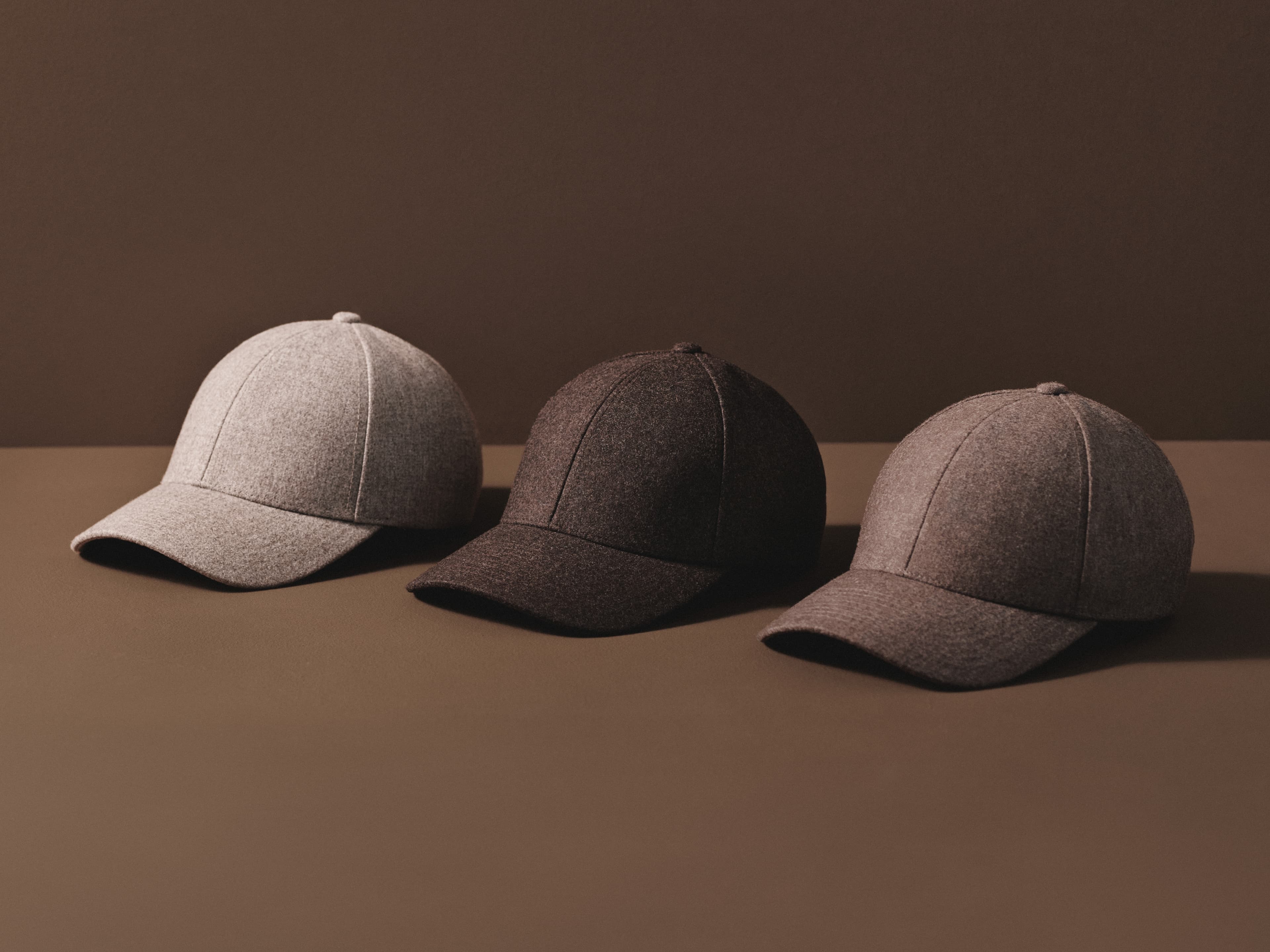 Lineup of wool caps in brown colors with brown background