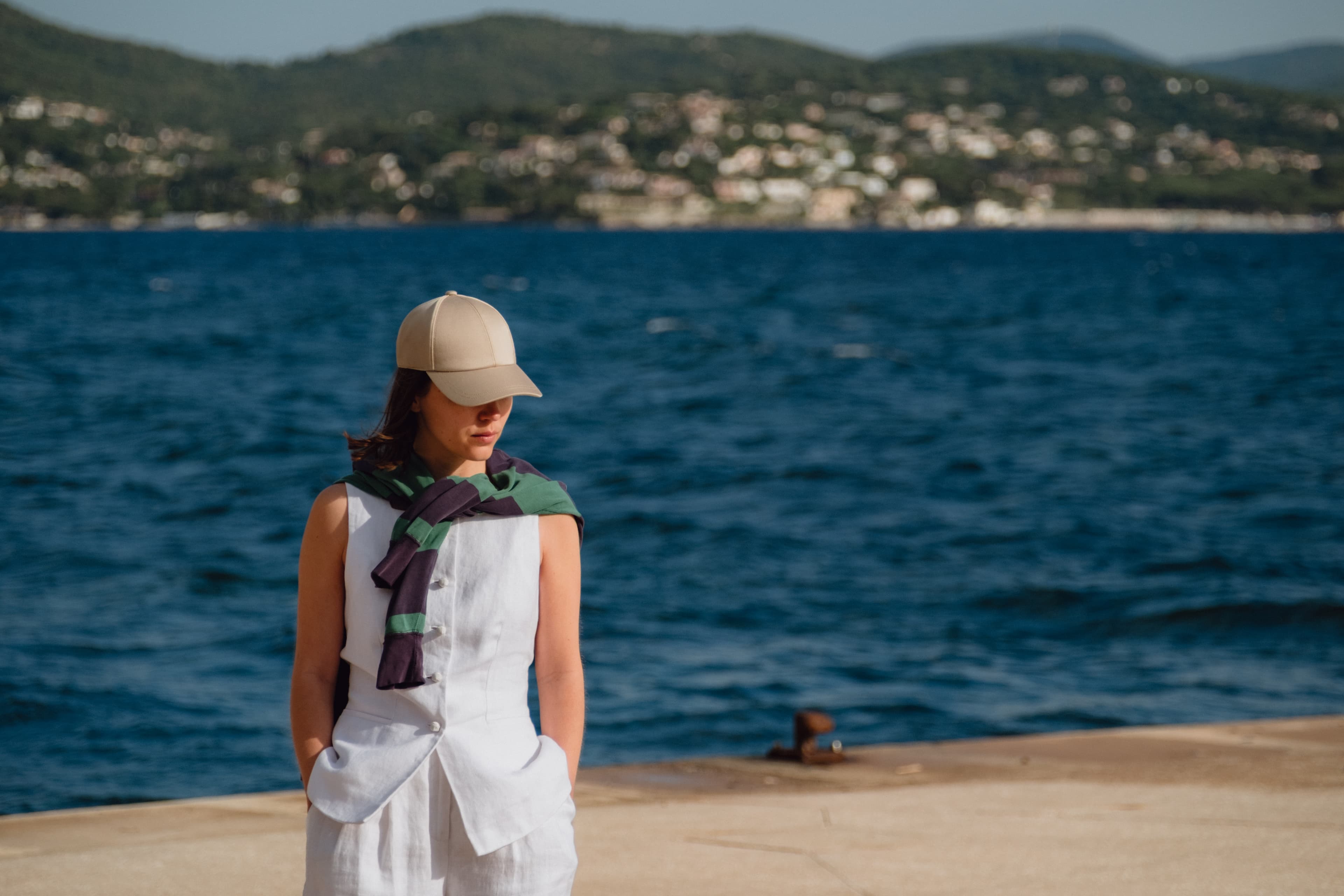 Front view of female wearing a beige sea island cotton cap by the sea
