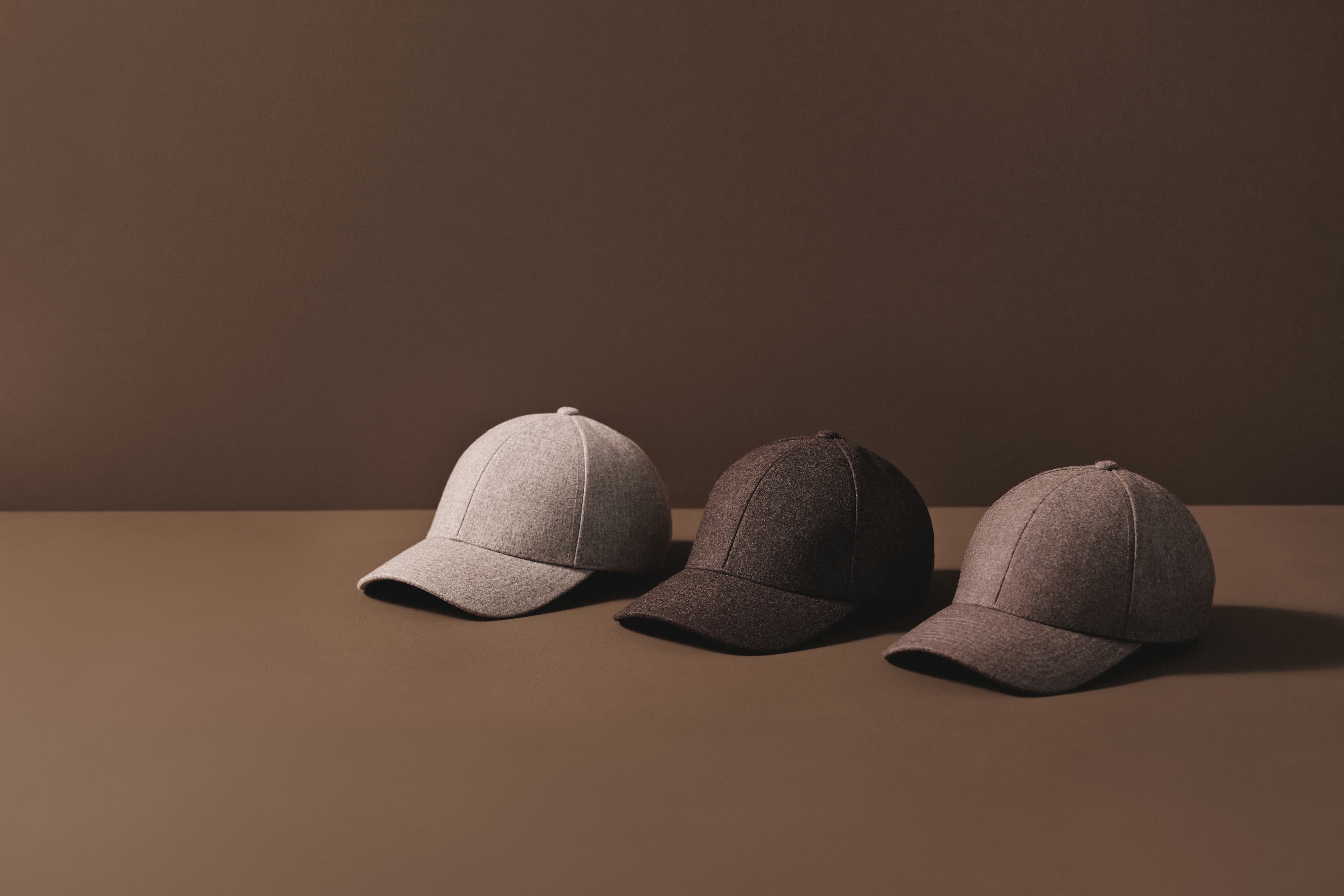 Lineup of wool caps in brown colors with brown background