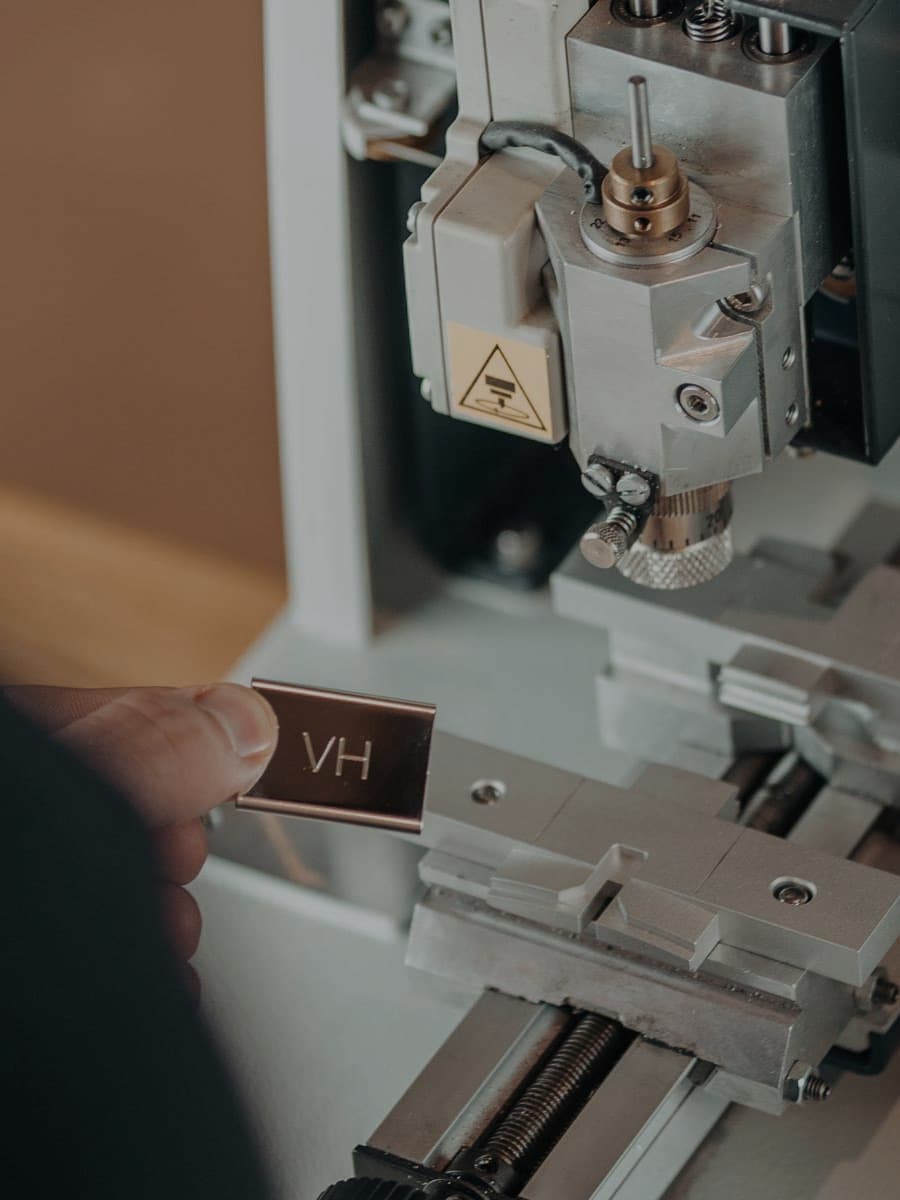 Custom engraving plate from Varsity Headwear's machine, creating personalized co-branded baseball caps for selected partners