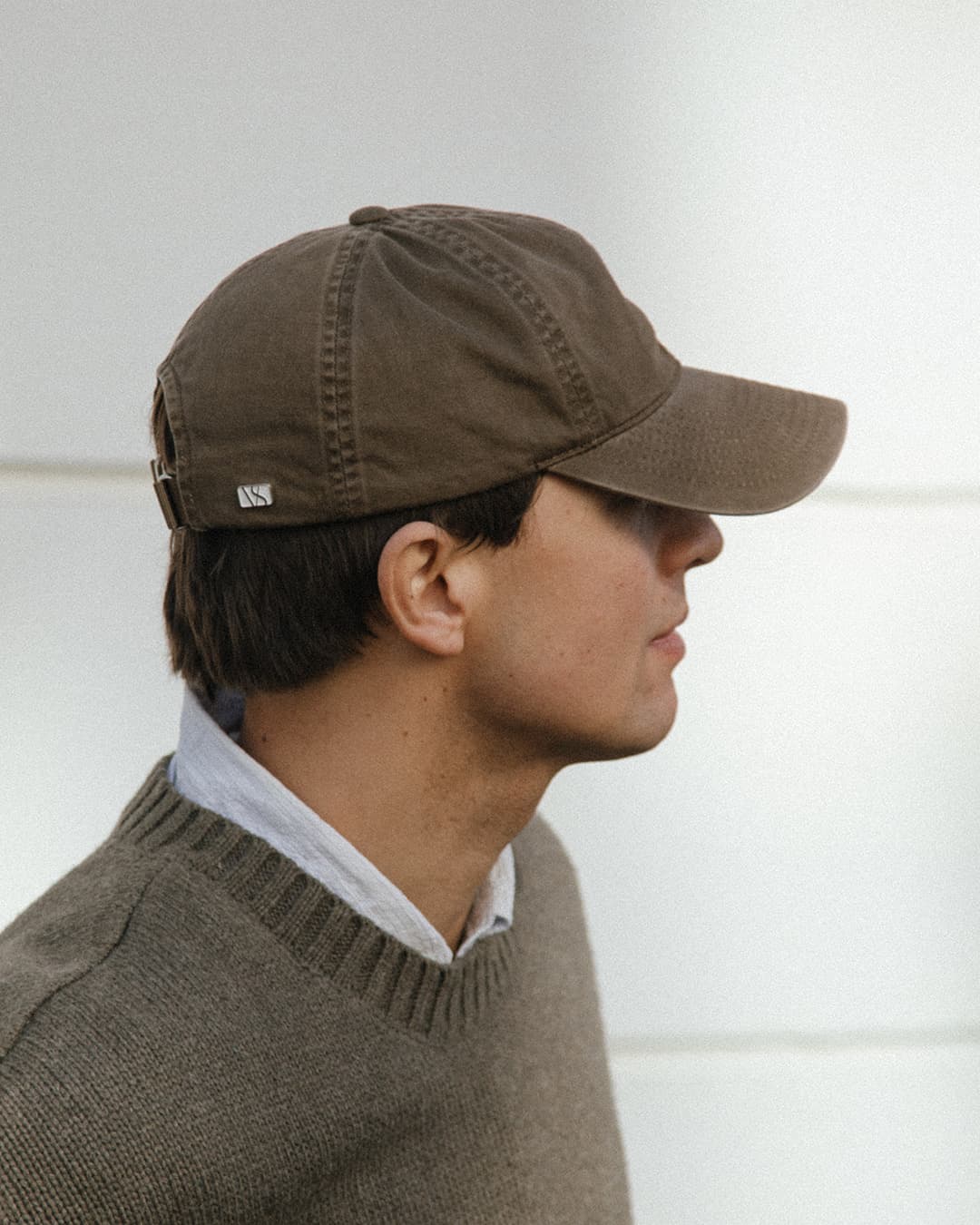 Side view of male model wearing a beige washed cotton cap