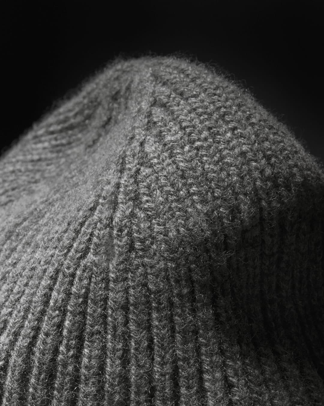 Close view of the top of a grey cashmere wool blend beanie from varsity headwear