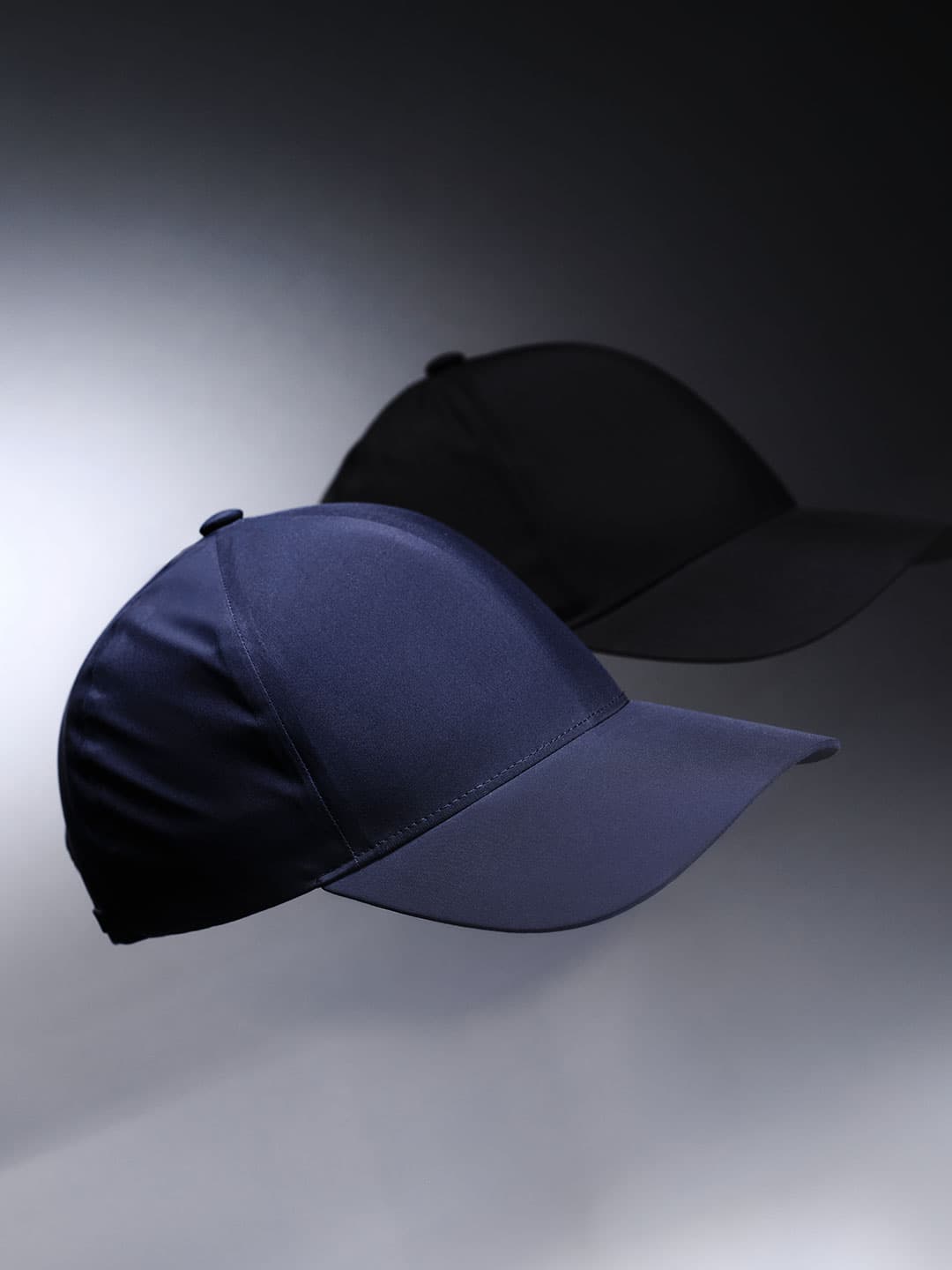 Side view of two legacy structured low intensity sports caps from Varsity Headwear in Navy and black
