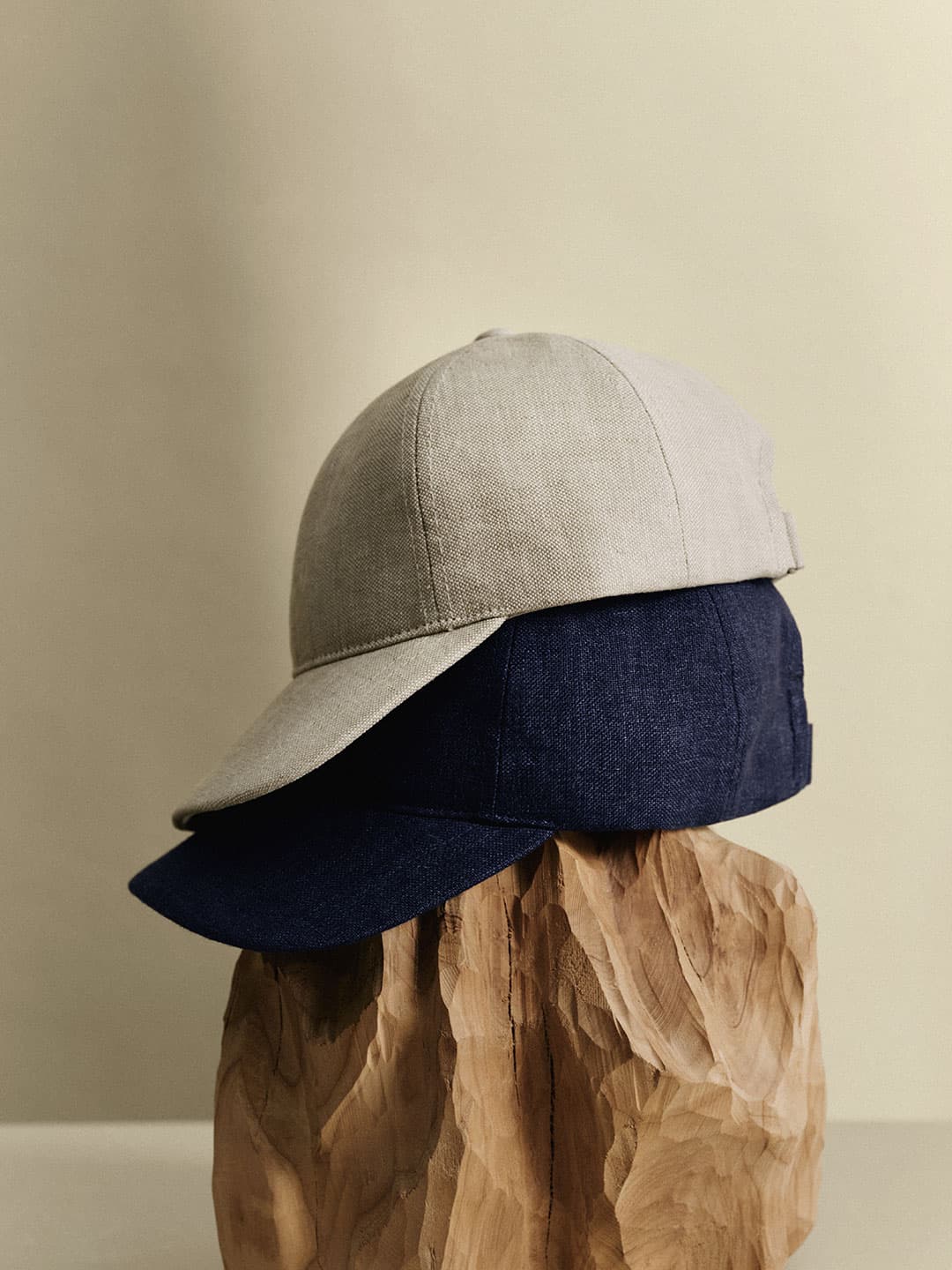 Side view of beige and navy linen caps from Varsity Headwear