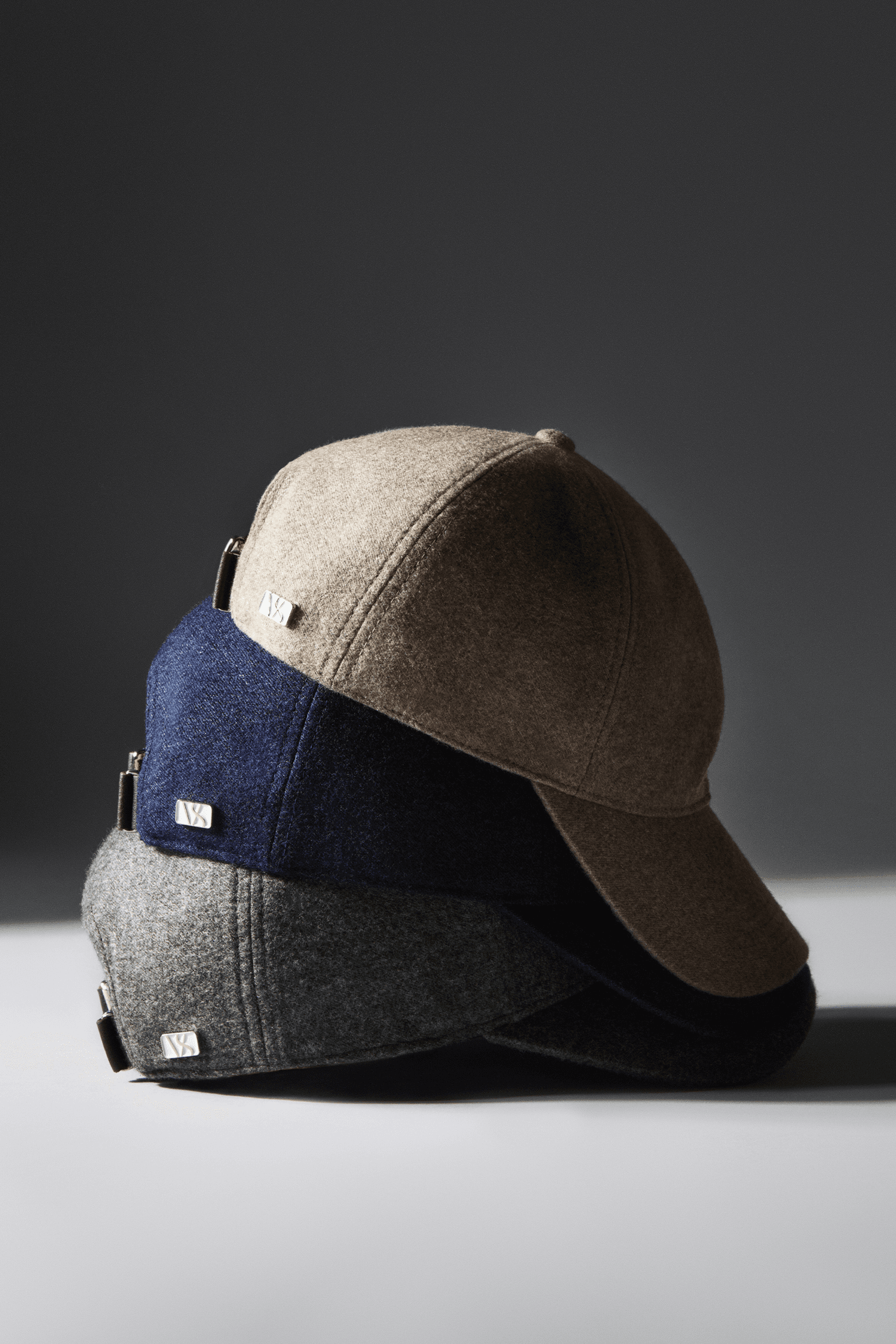 Side view of Loro Piana cashmere caps in blue, green and beige from Varsity Headwear