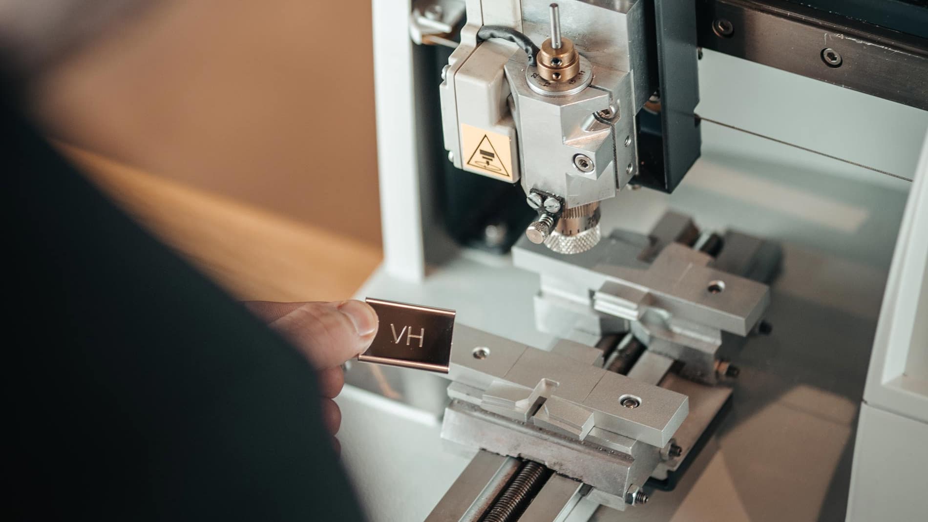 Custom engraving plate from Varsity Headwear's machine, creating personalized co-branded baseball caps for selected partners