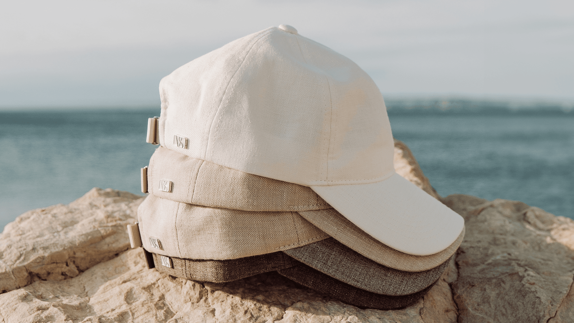Side view of linen caps from varsity headwear in white and brown colors in a summer environment