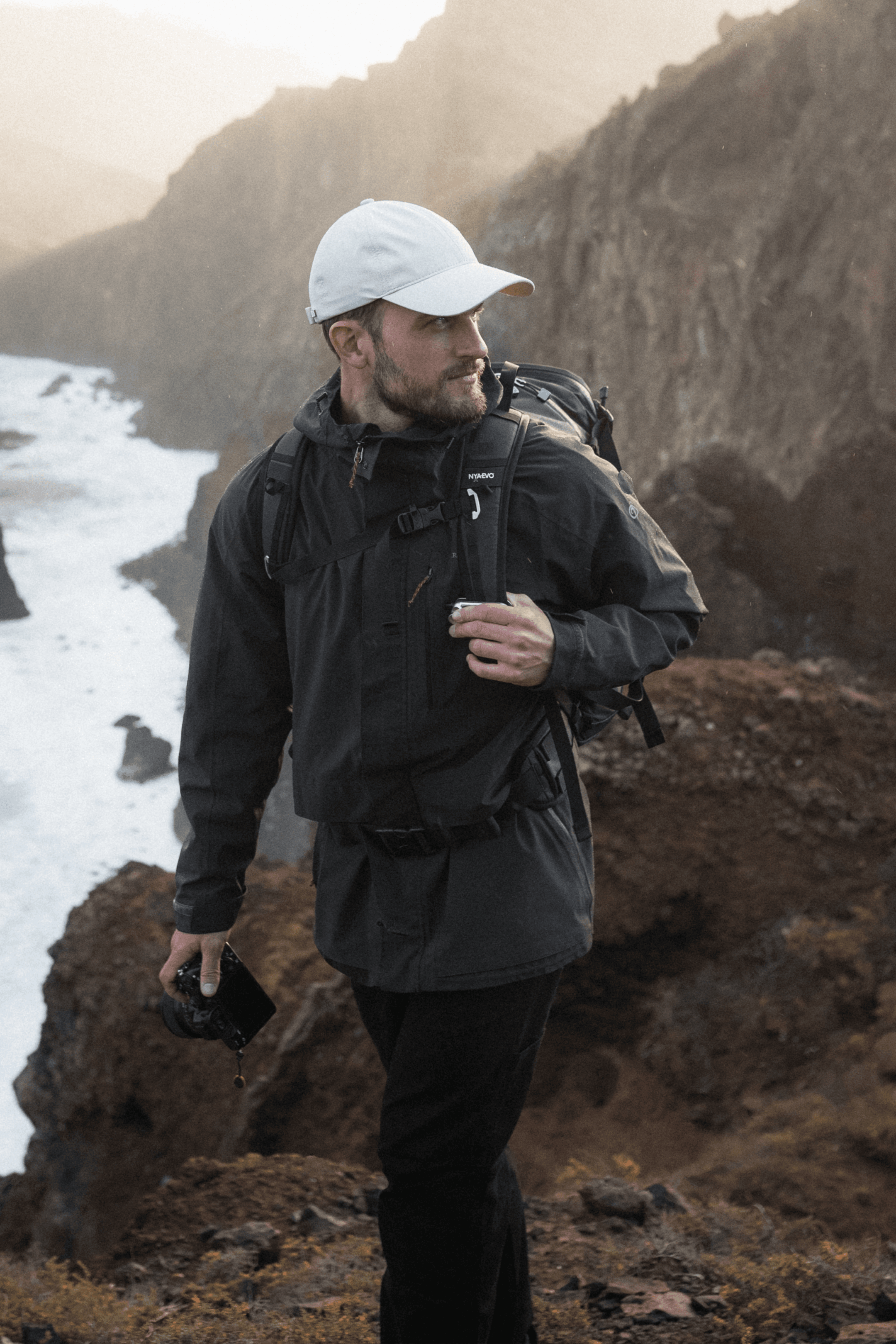 Front view of a male wearing a white active tech in beautiful landscape