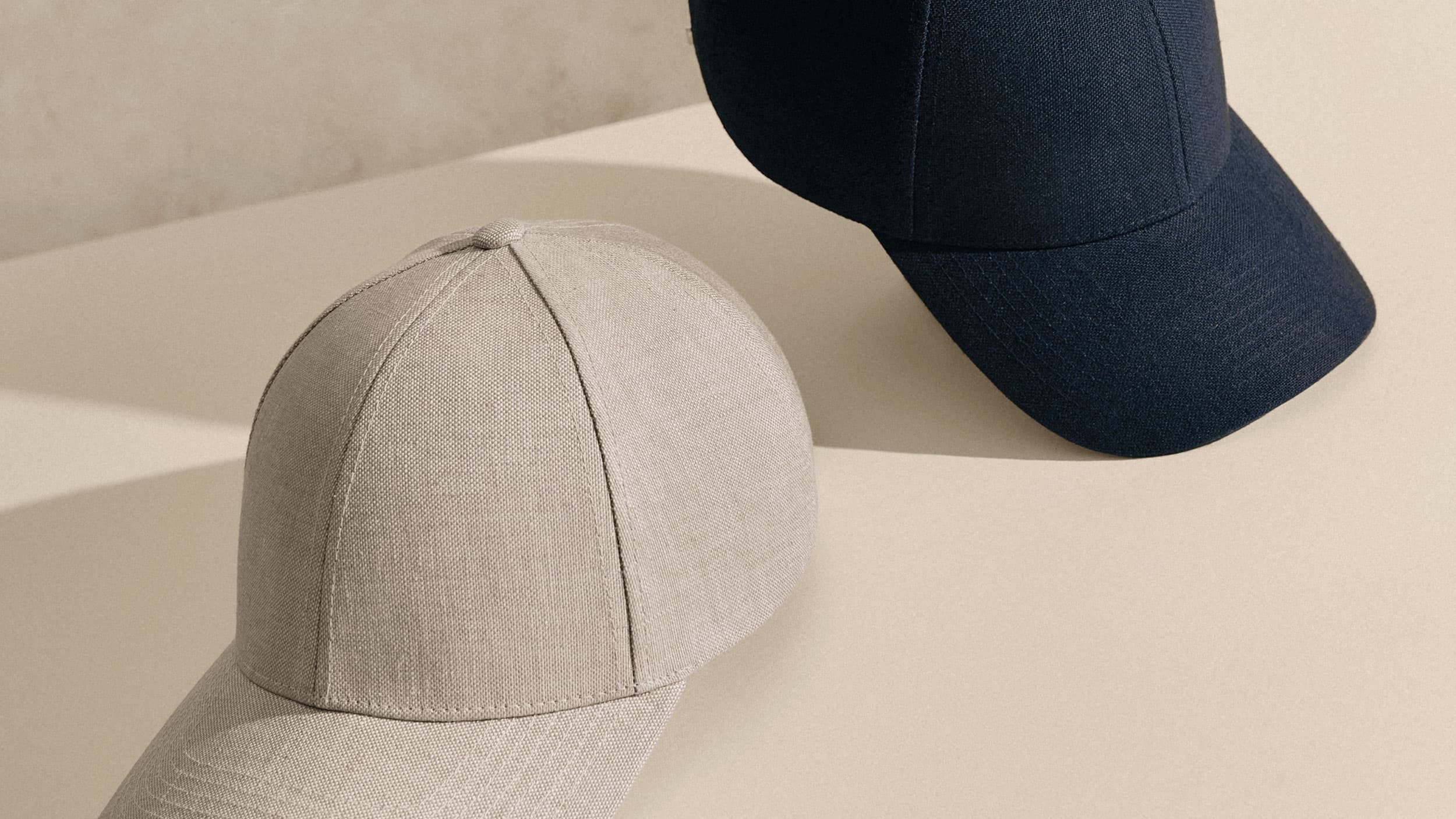 Bestsellers hampton beige and deep sea navy caps on beige surface.
