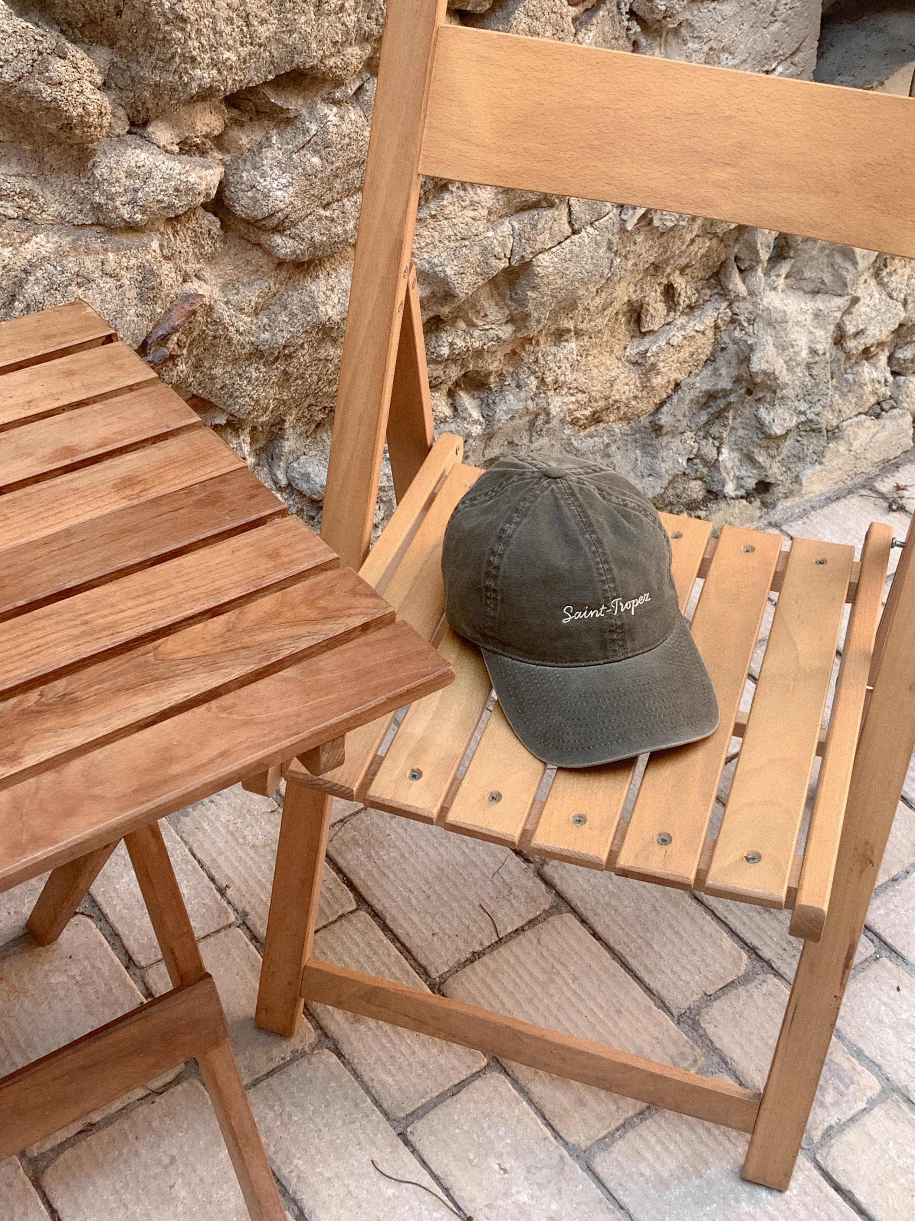 Front view of a beige washed cotton cap with saint tropez written in front
