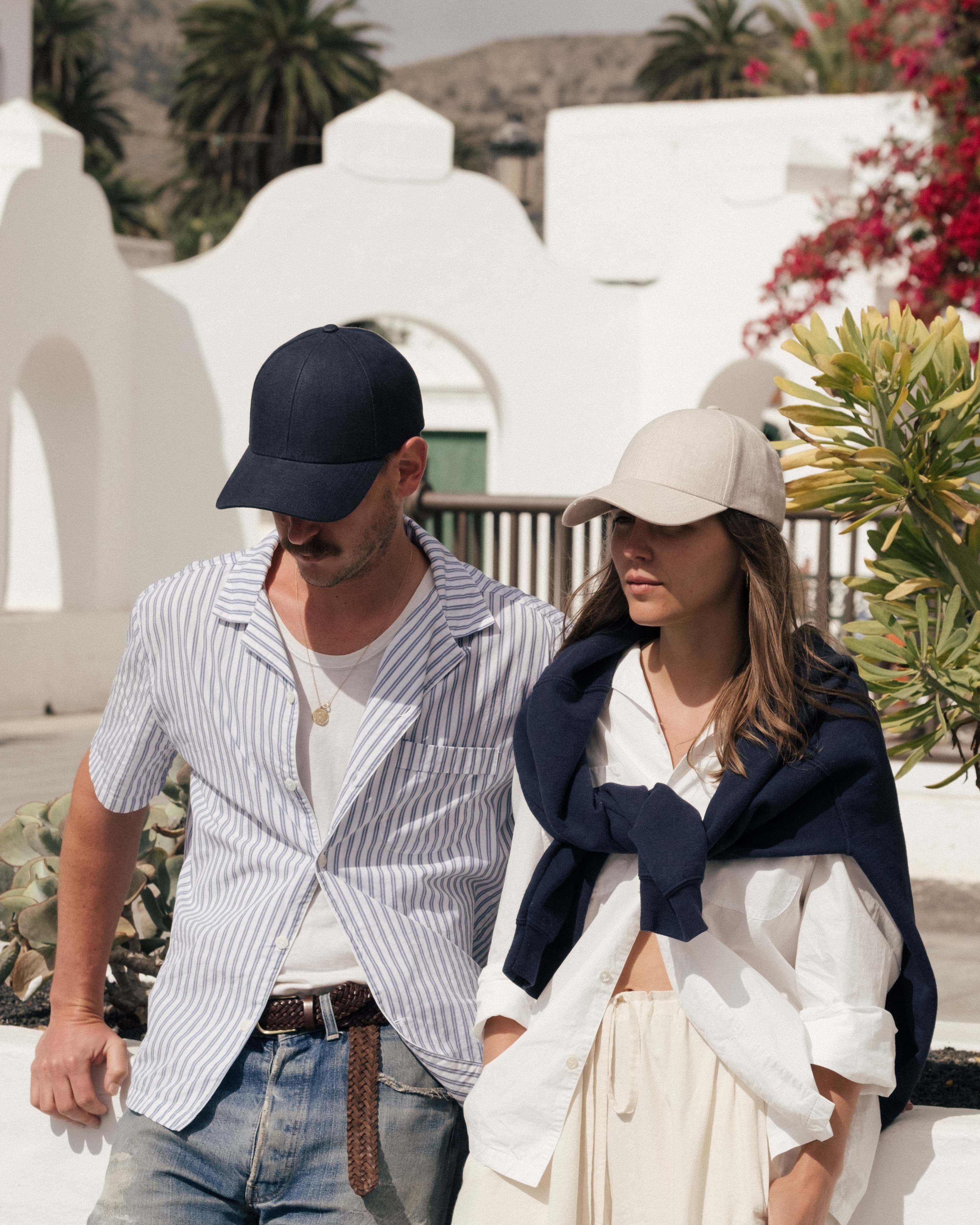 Front view of female and male model wearing beige and navy cap for summer 23 campaign shoot