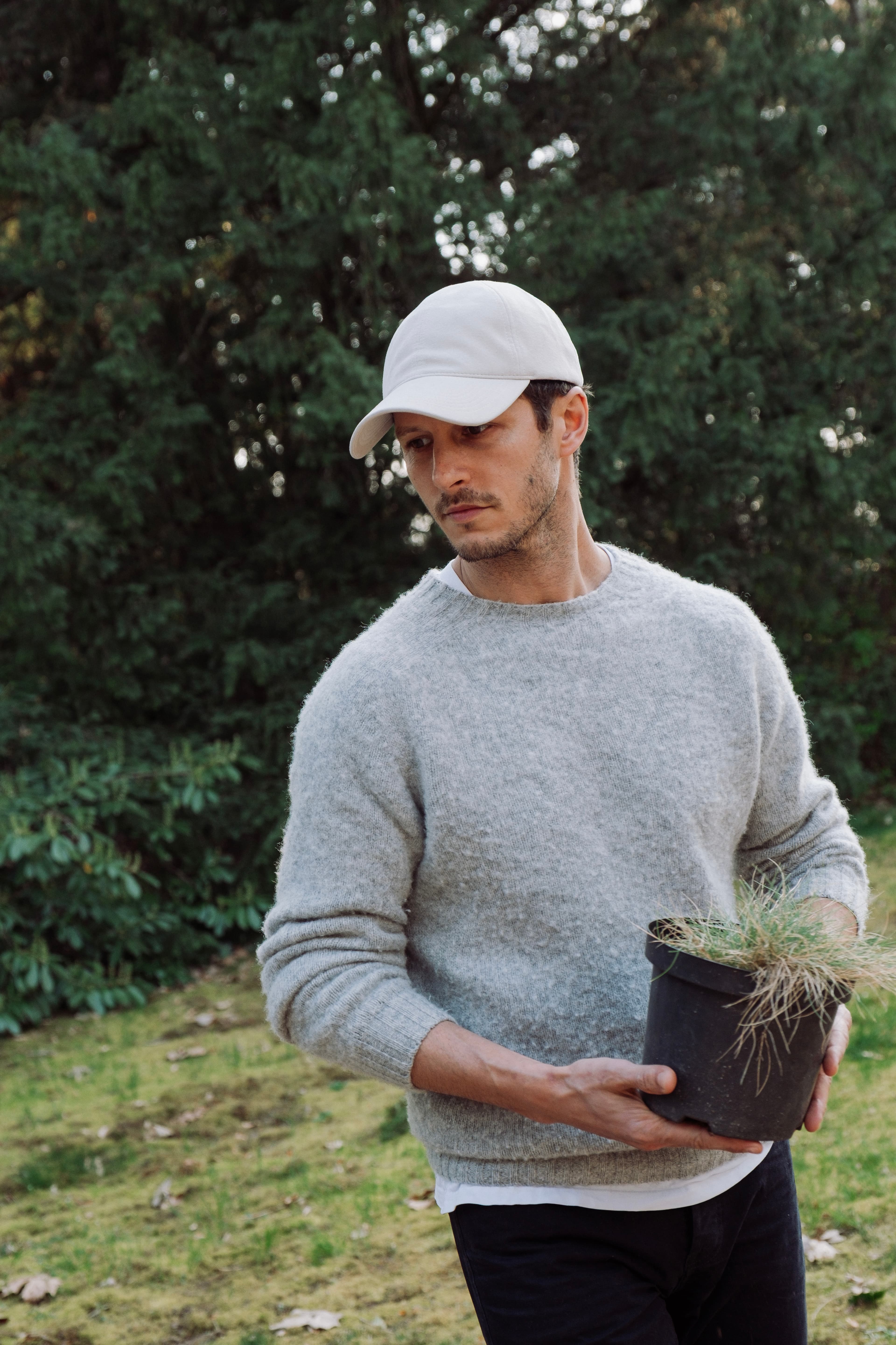 Hedi Sersoub Varsity Headwear ambassador at the country side working in the garding wearing a white alcantara cap