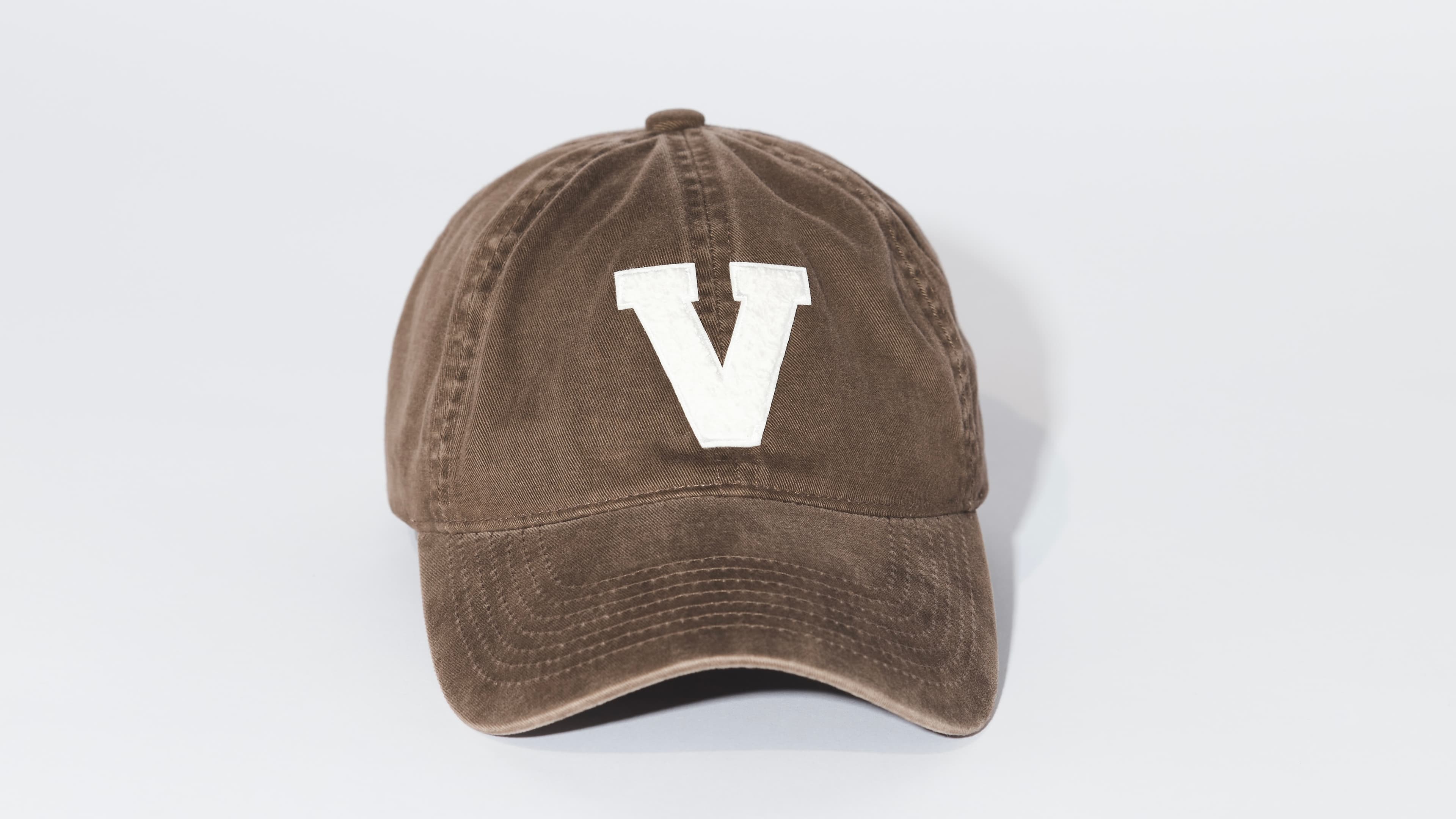 Front view of a beige washed cotton cap with a patch