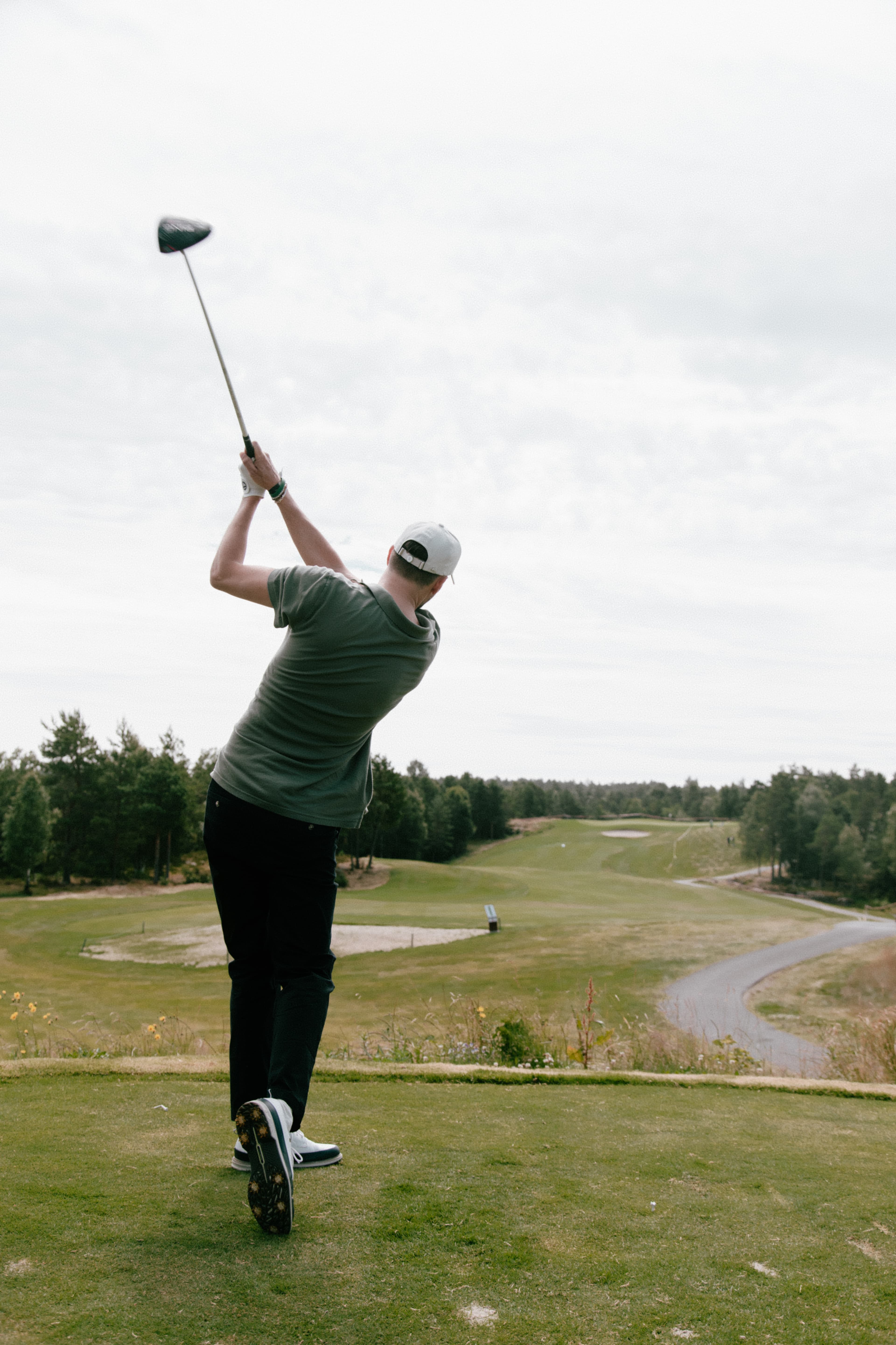 Back view of golf player wearing Varsity Headwear cap