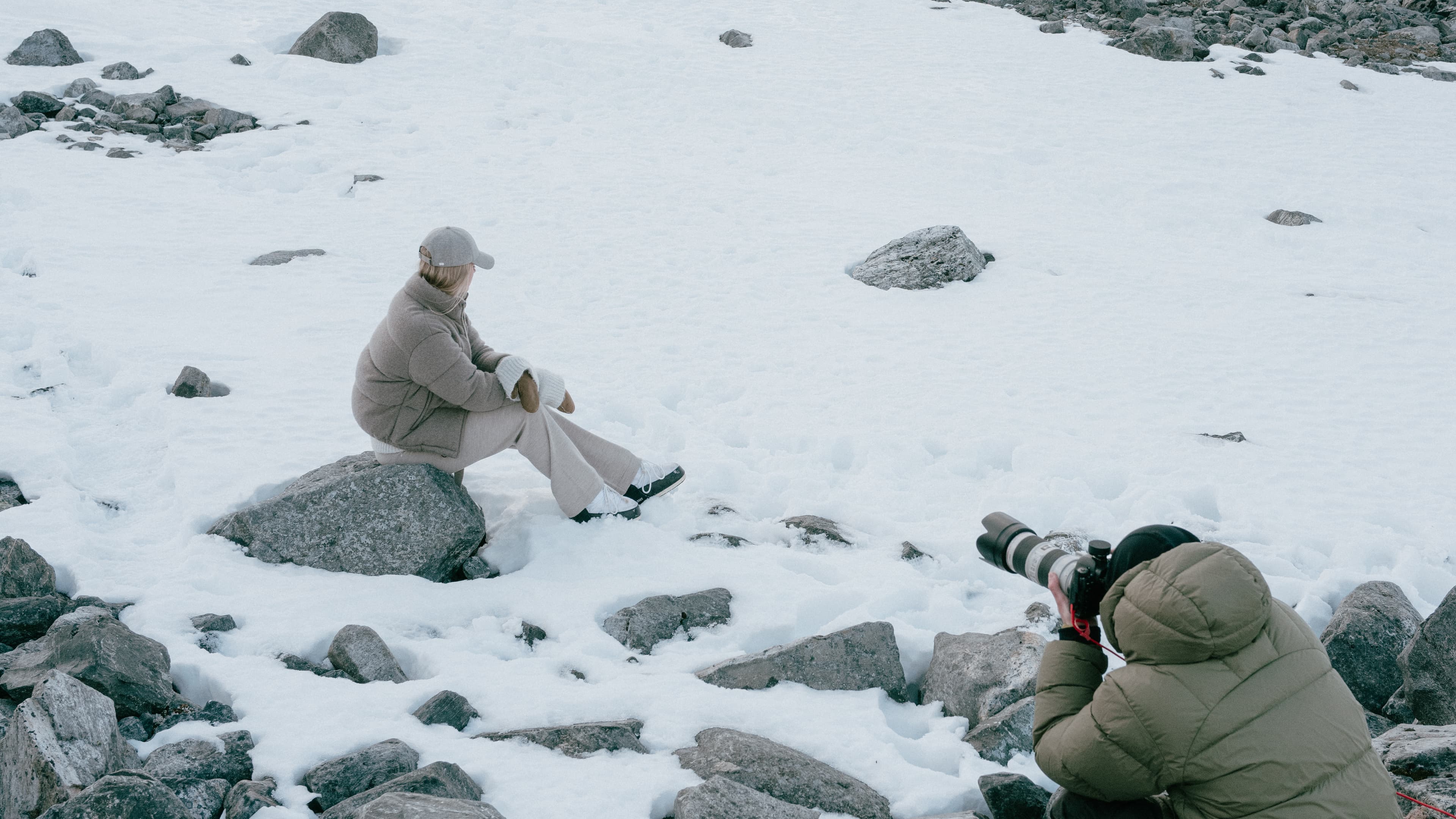 Behind the scenes photo of photographer from the VH holiday 24 shoot and model wearing grey wool cap in norwegian landscape