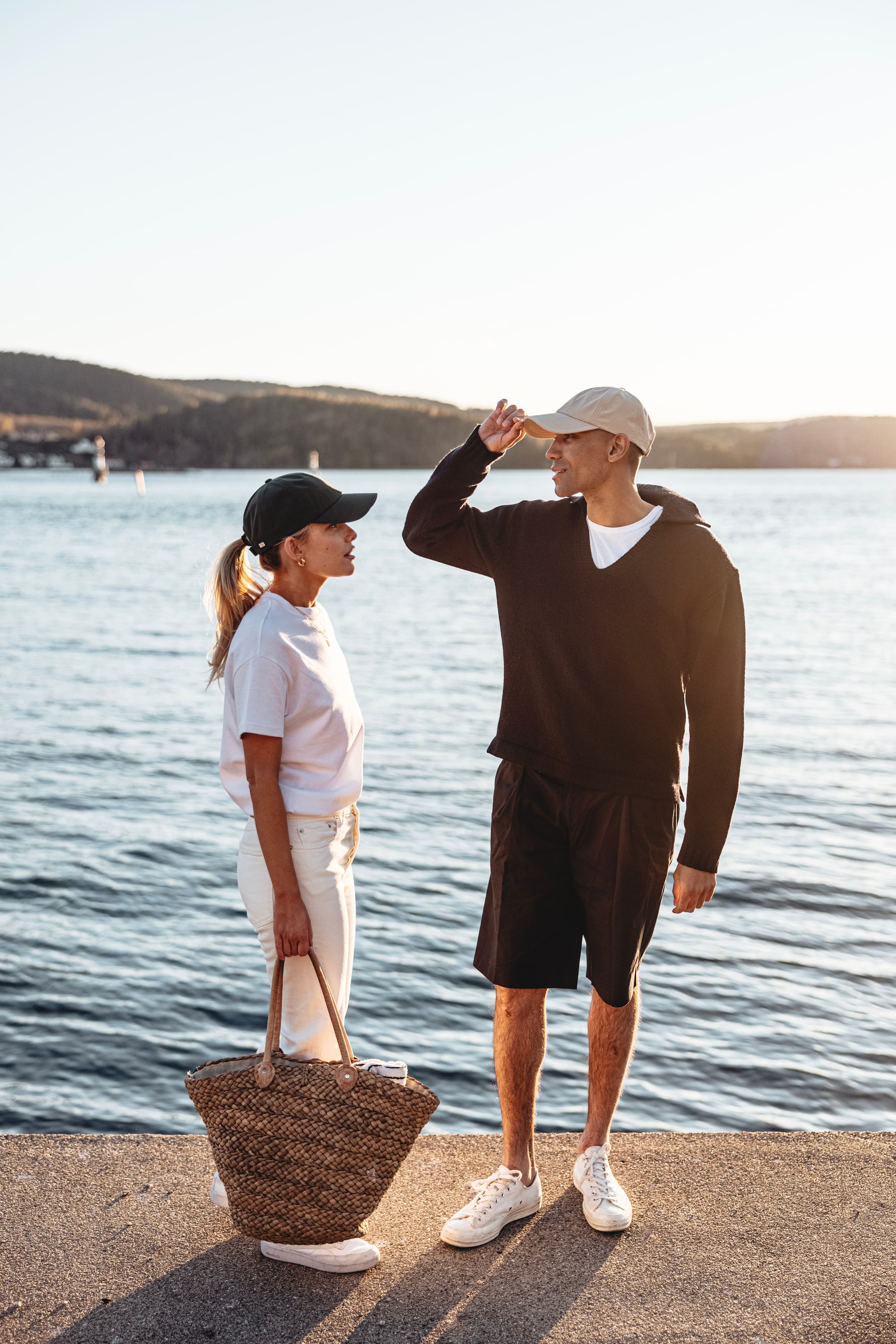 Side view of friends wearing seaqual caps by the ocean during summer time