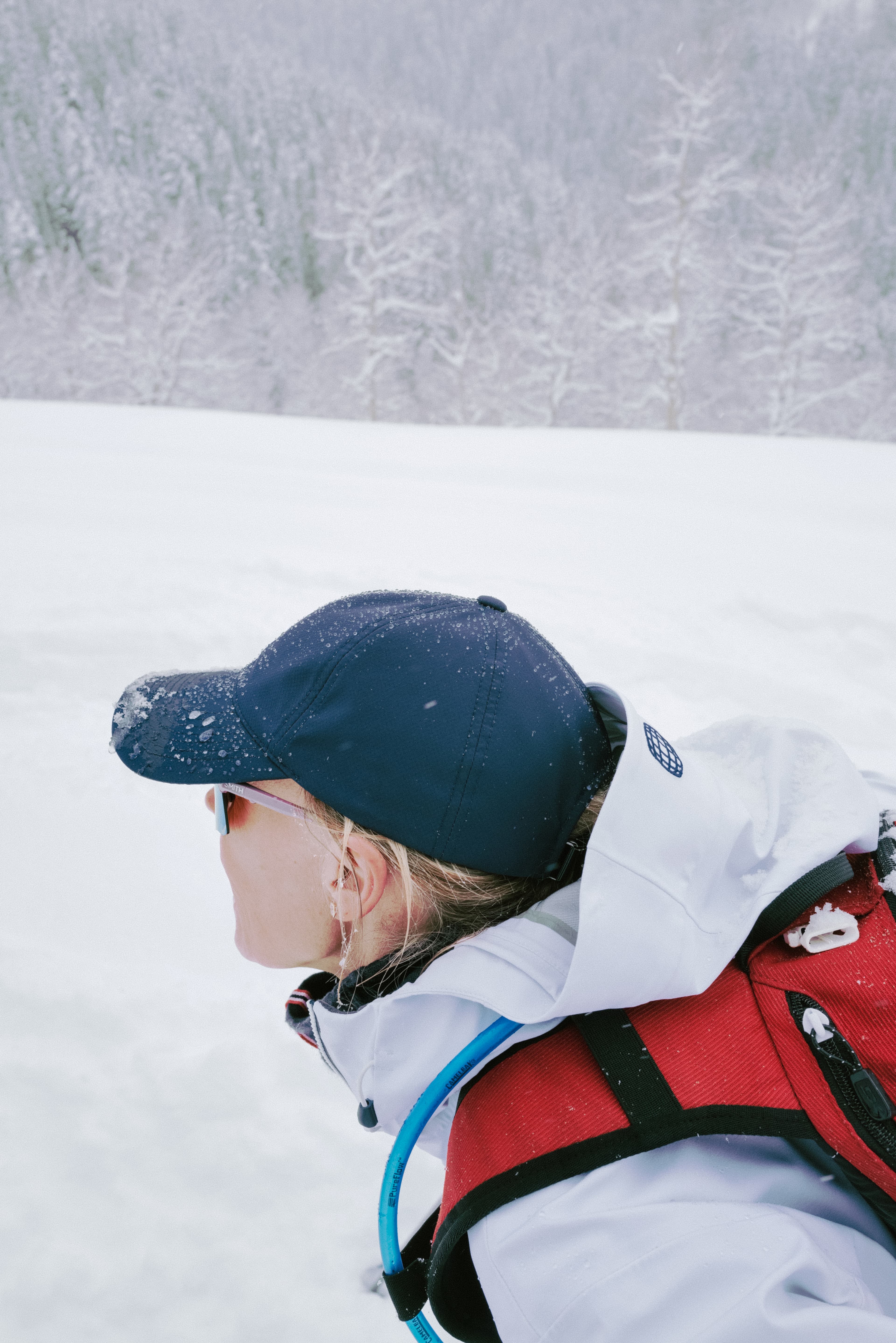 Side view of female wearing active tech cap in snowy environment