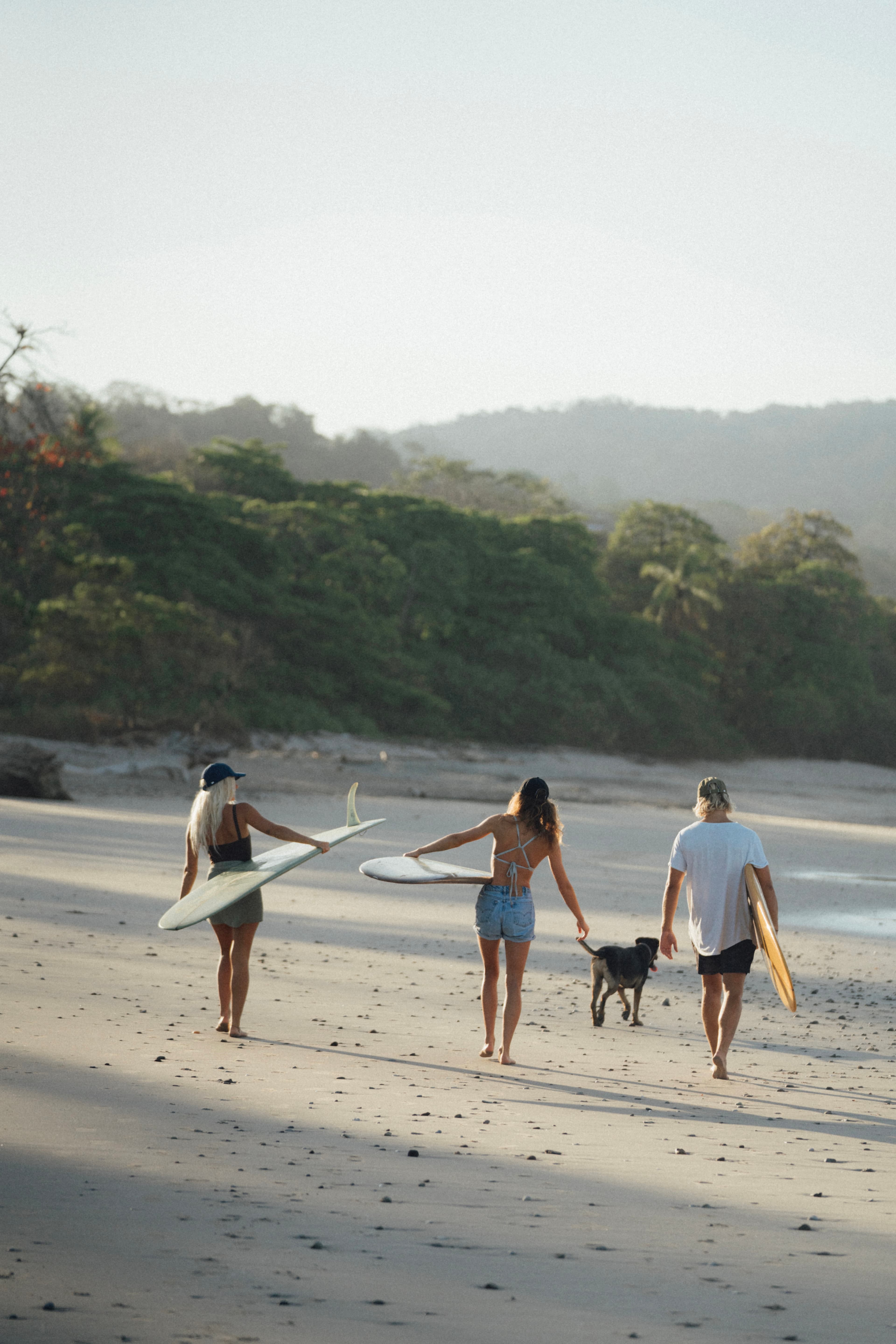 Friends wearing seaqual caps at the beach surfing in Costa Rica