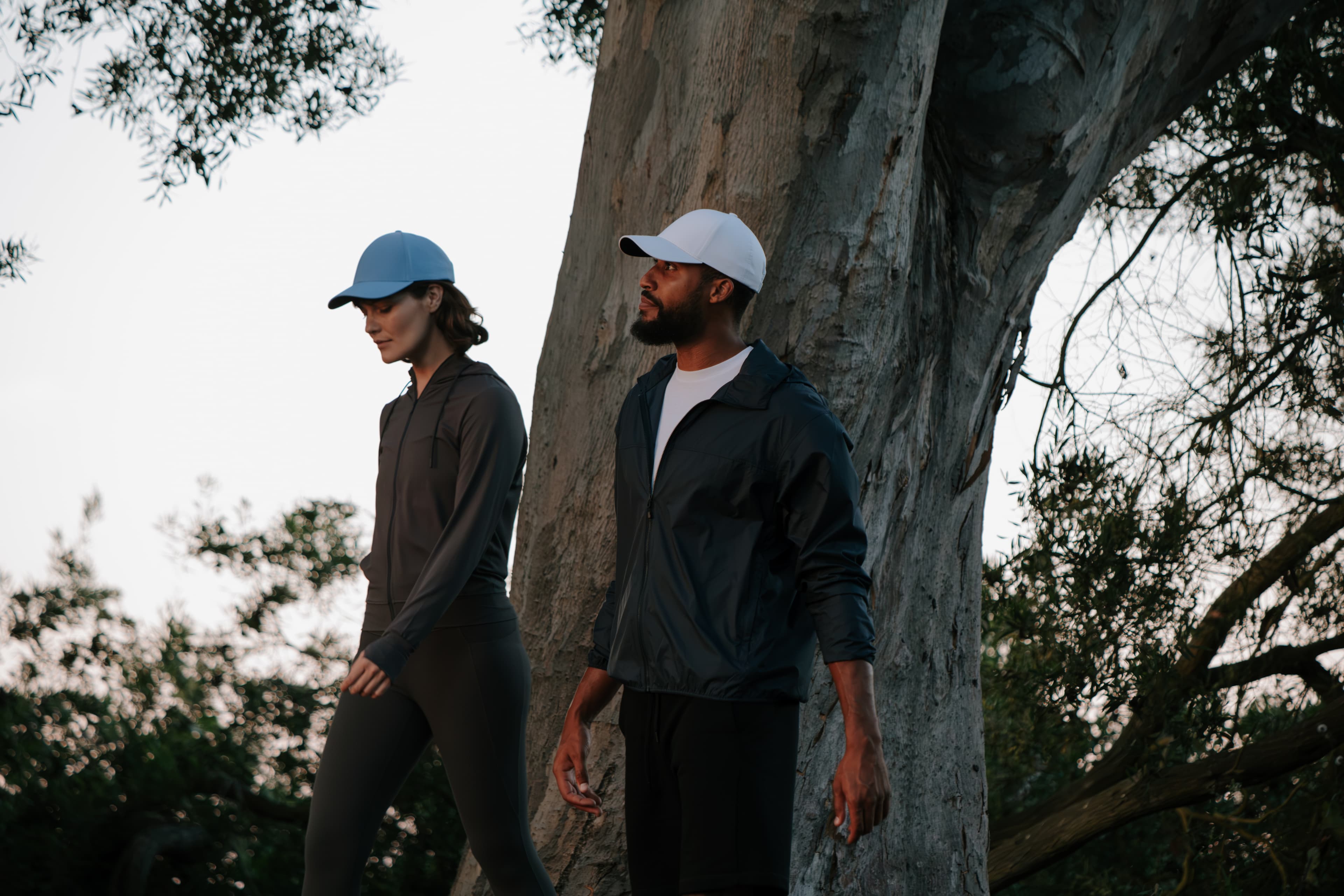 Male and female model wearing athletic sports cap in blue and white while being active