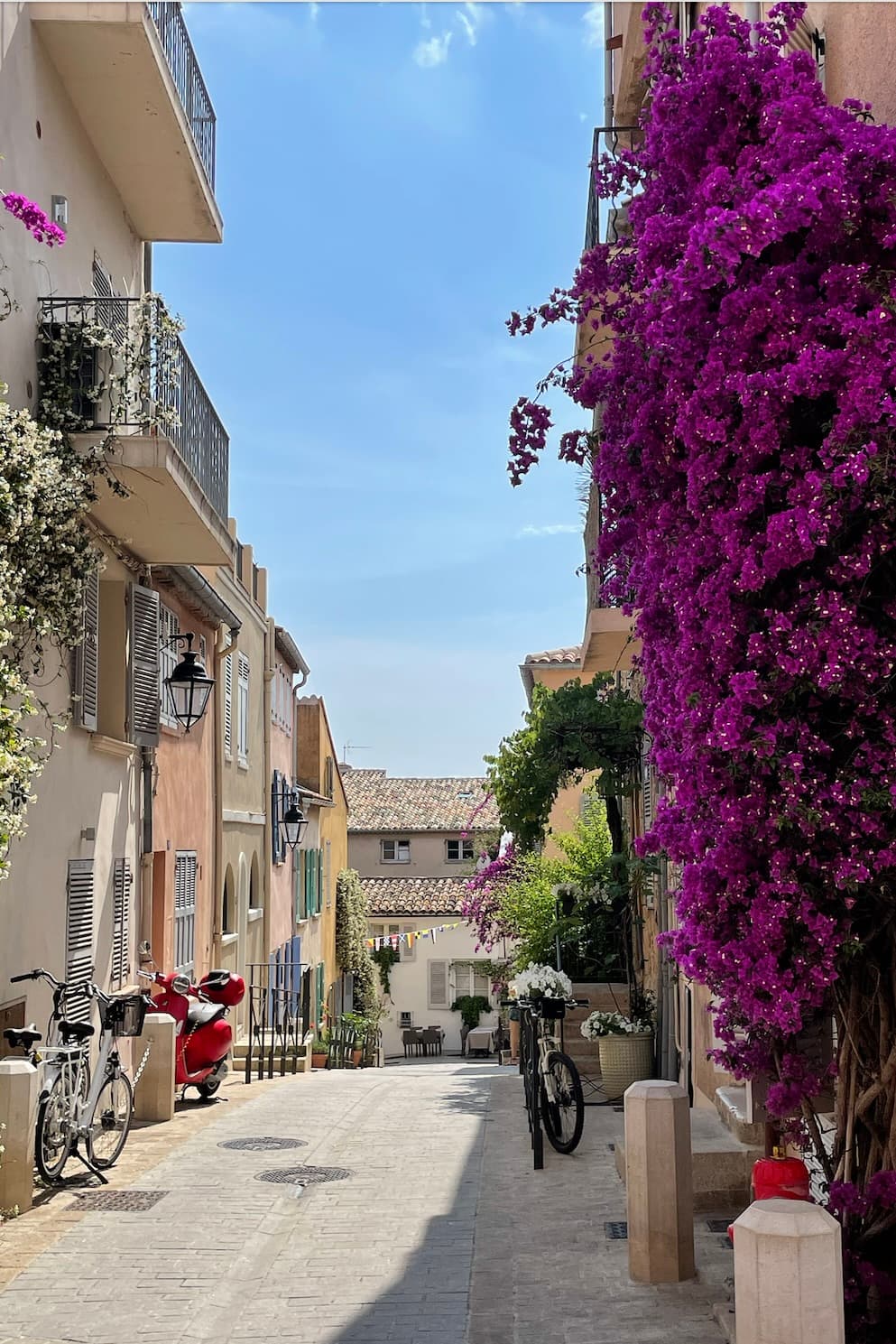 Streets of old town in Saint-Tropez in France with flowers and bikes