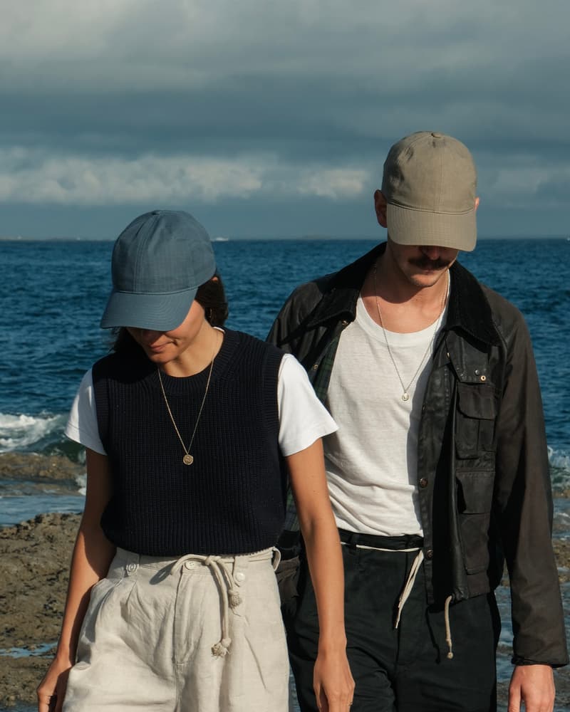 Front view of female and male model wearing legacy soft oilskin caps in summer environment