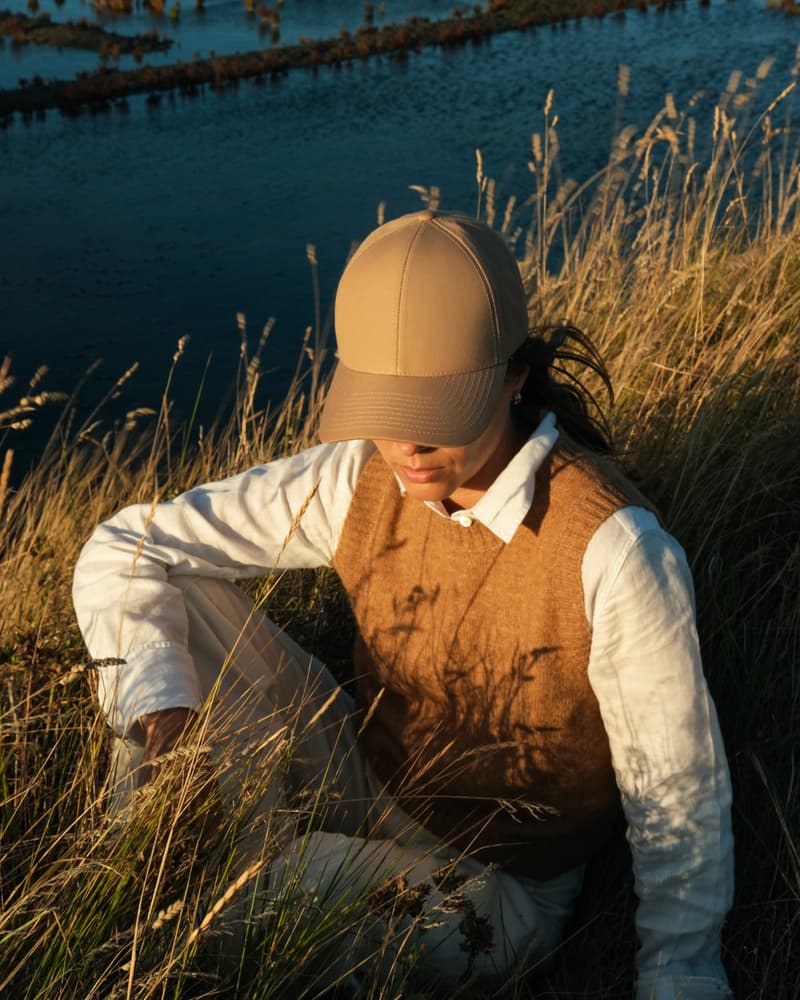 Front view of female model wearing a ventile cotton cap in outdoor environment